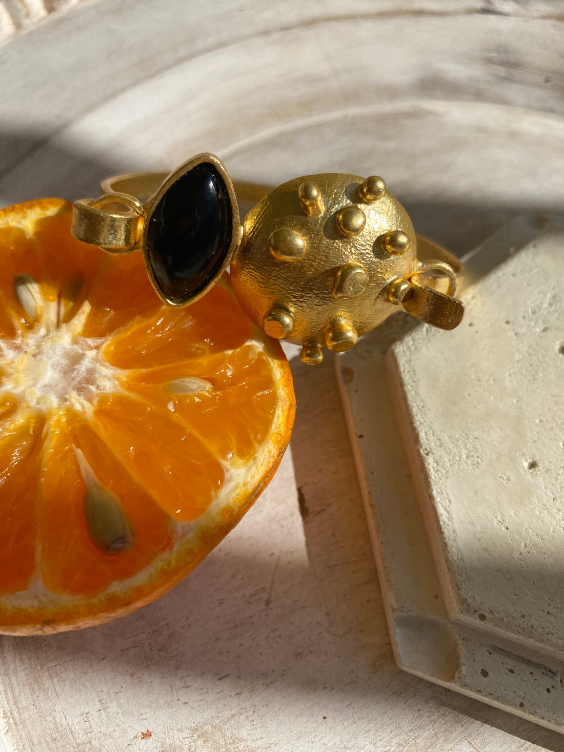 18k gold-plated cuff bracelet featuring a oval black onyx stone and dotted design.