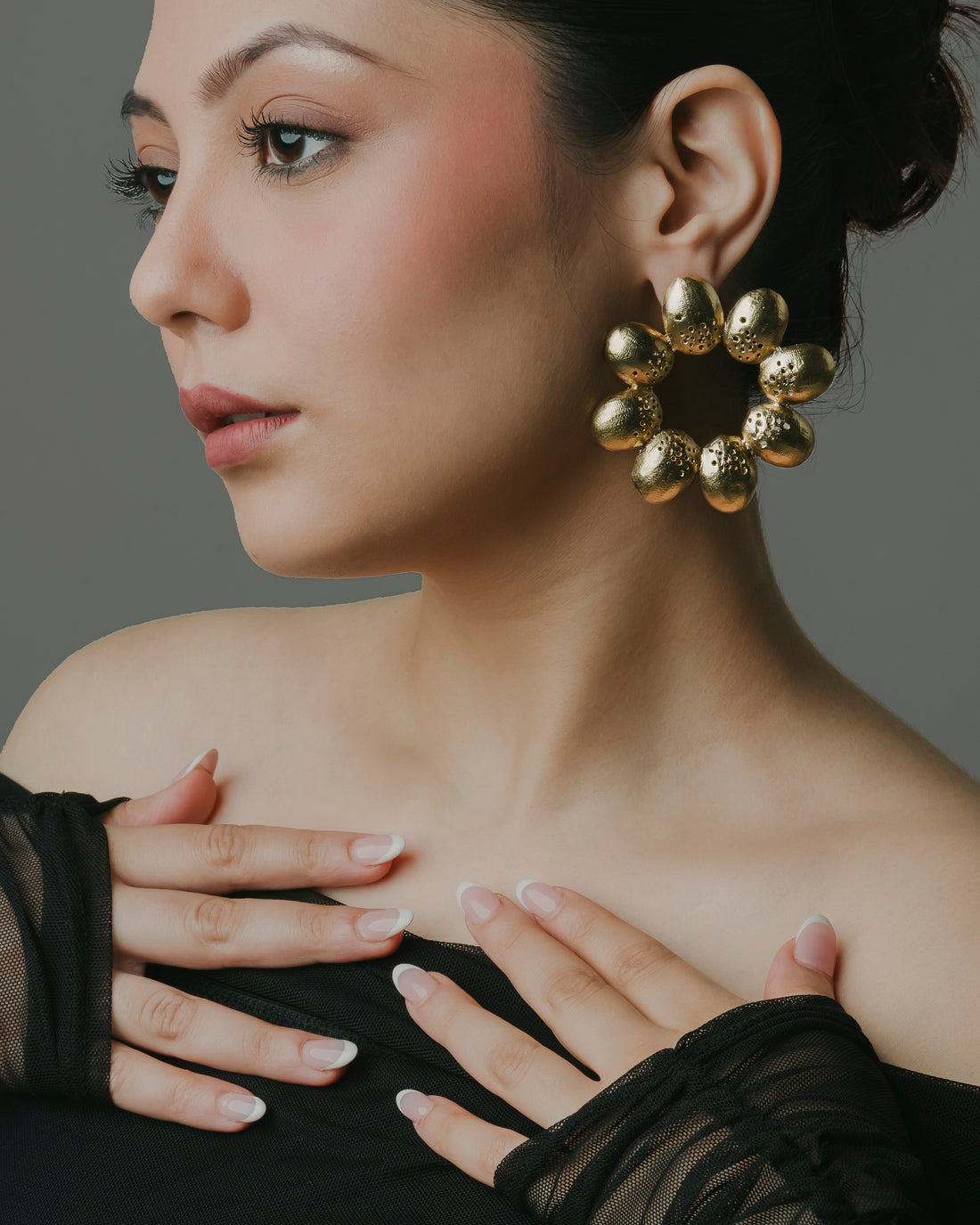 Model wearing 18k gold-plated textured floral hoop earrings by Baalajewels