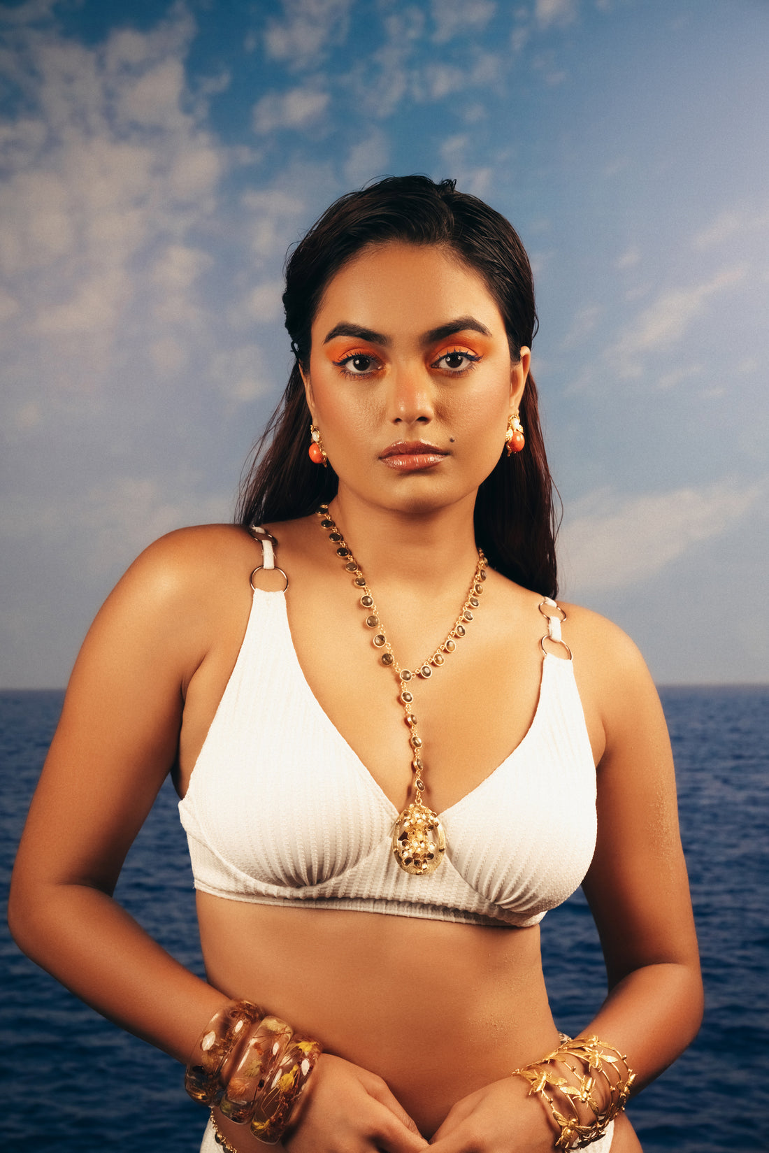 Woman wearing a long 18k gold-plated floral Y-necklace featuring an intricate filigree pendant.