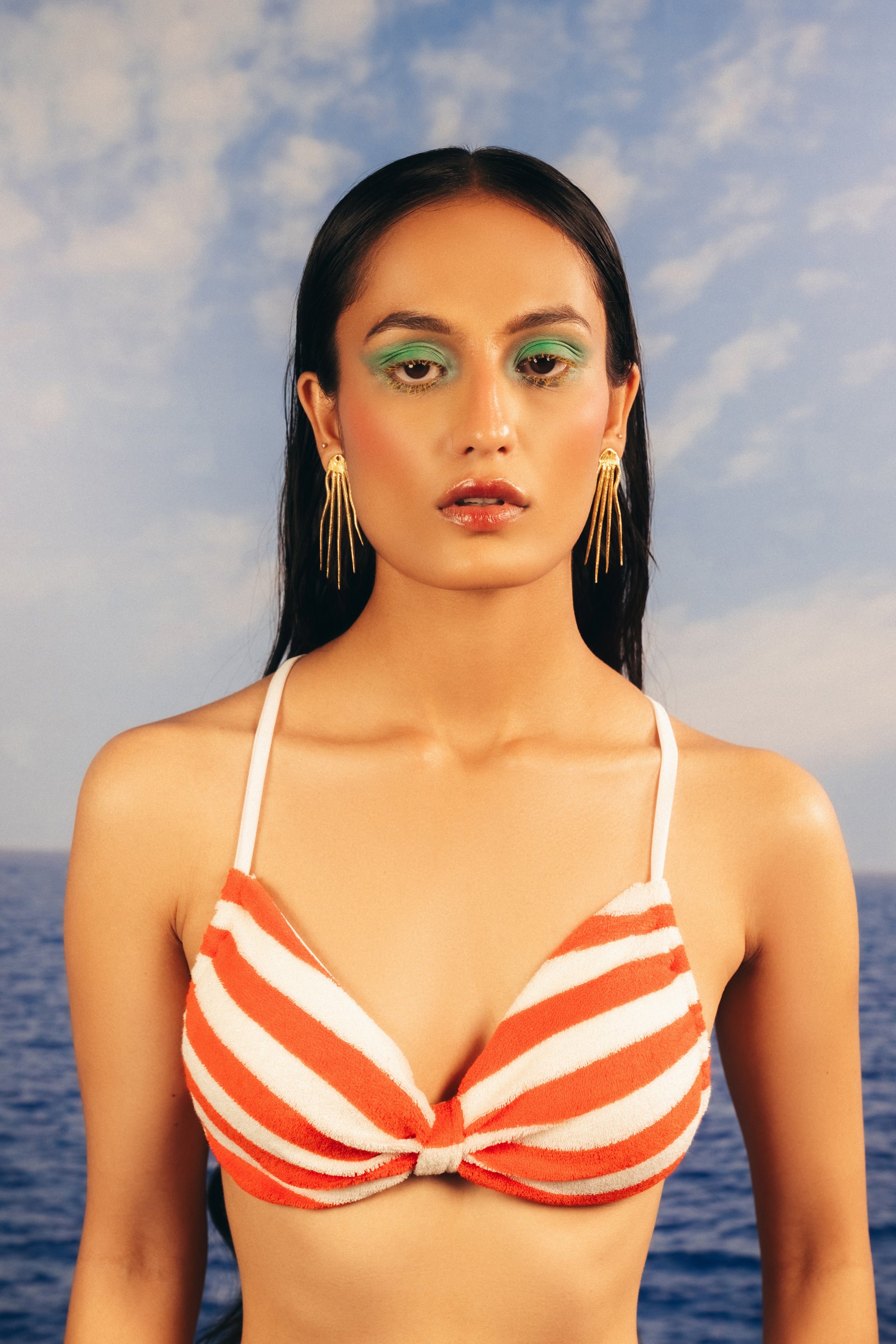 Abstract gold dangle earrings with organic gemstone accents styled on a model.