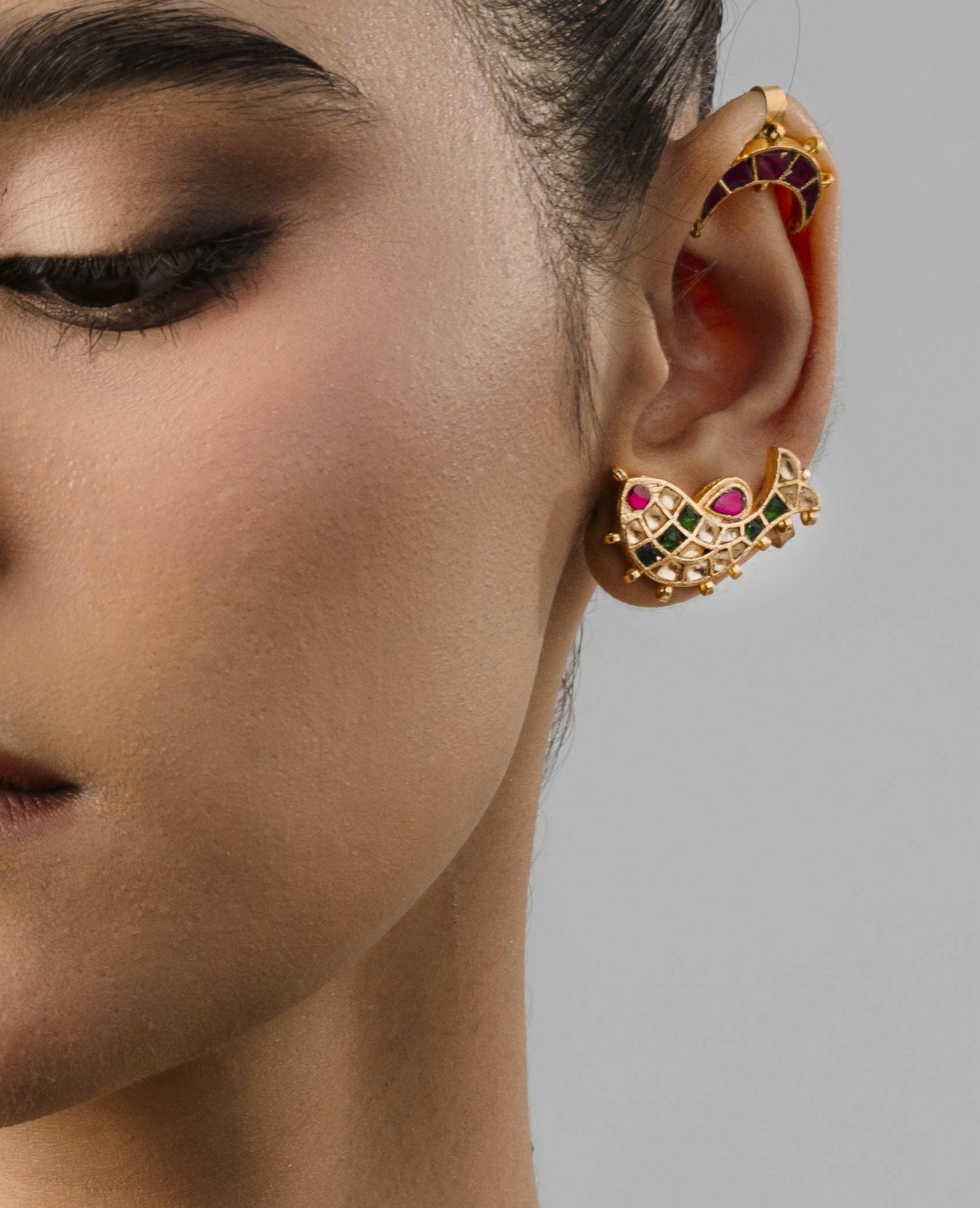 An adjustable, skin-friendly 18k gold-plated ear cuff designed in a fluid fish silhouette, perfect for luxury statement styling.