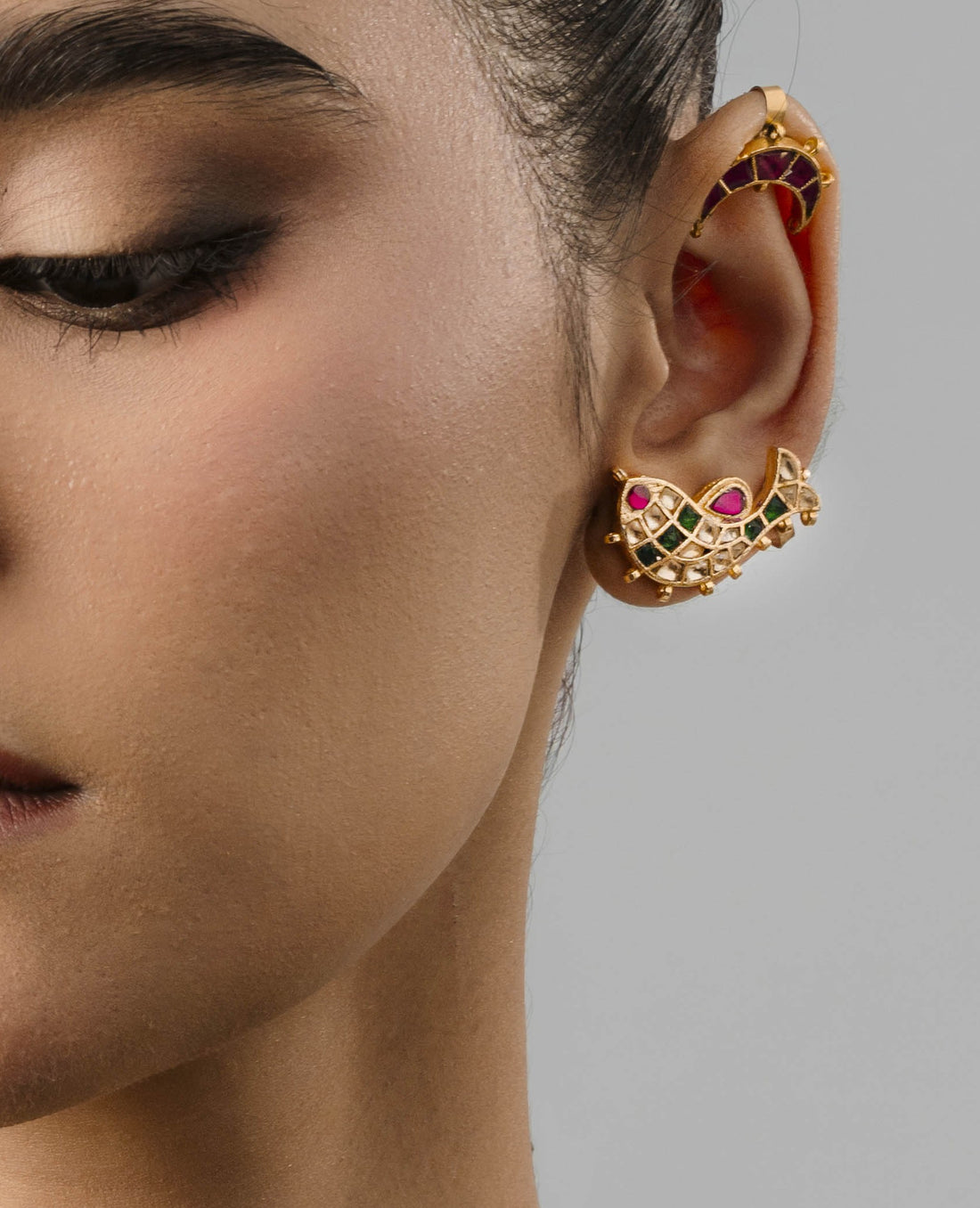 An adjustable, skin-friendly 18k gold-plated ear cuff designed in a fluid fish silhouette, perfect for luxury statement styling.