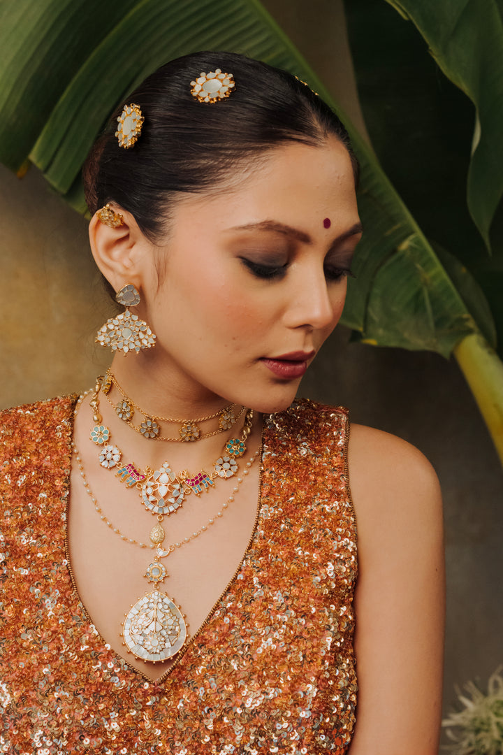 Woman modeling contemporary mother of pearl drop pendant necklace set with sequin deep V-neck saree blouse