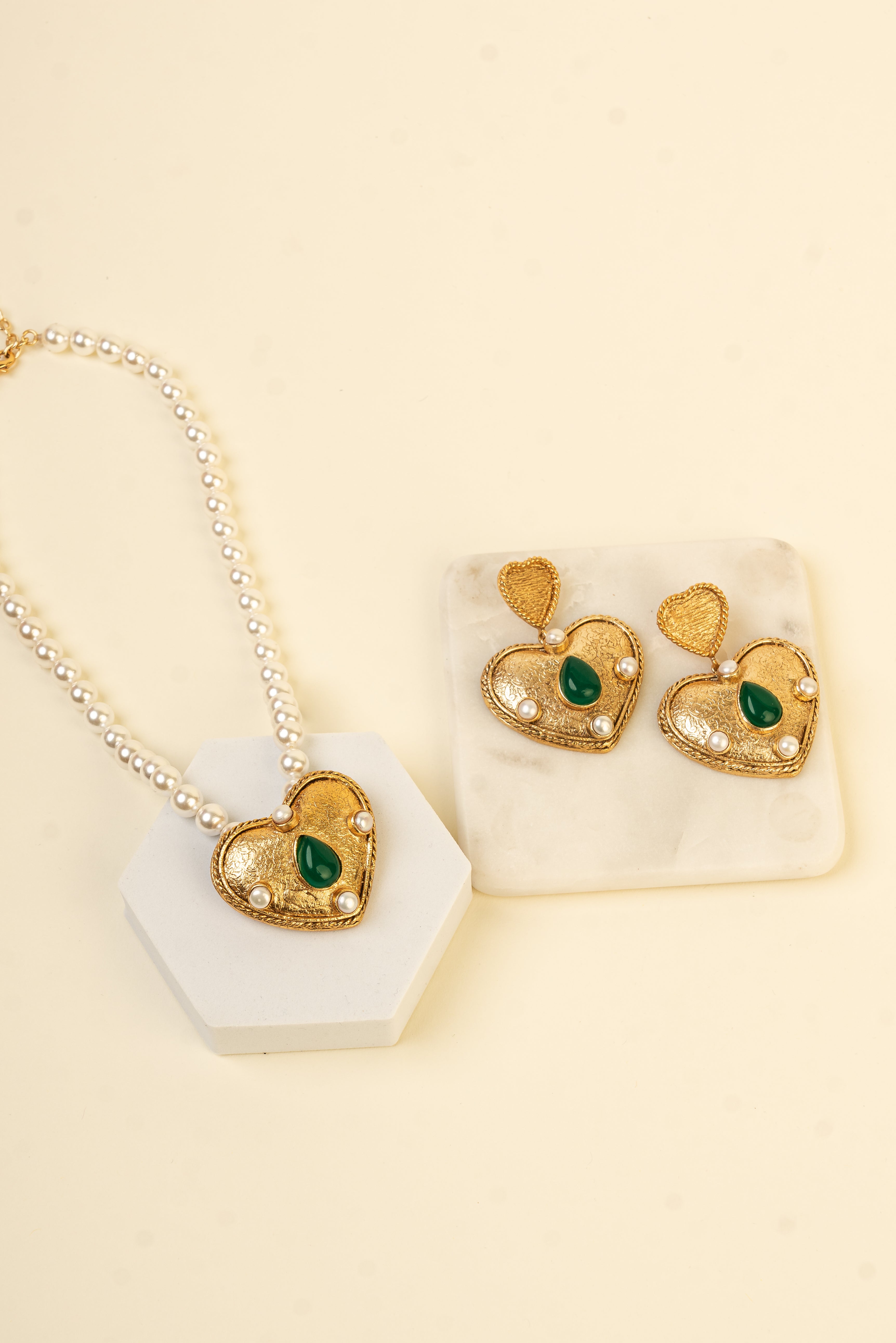 Baala Ethereal Heart Necklace with a pearl string band, gold heart pendant, and green gemstone.