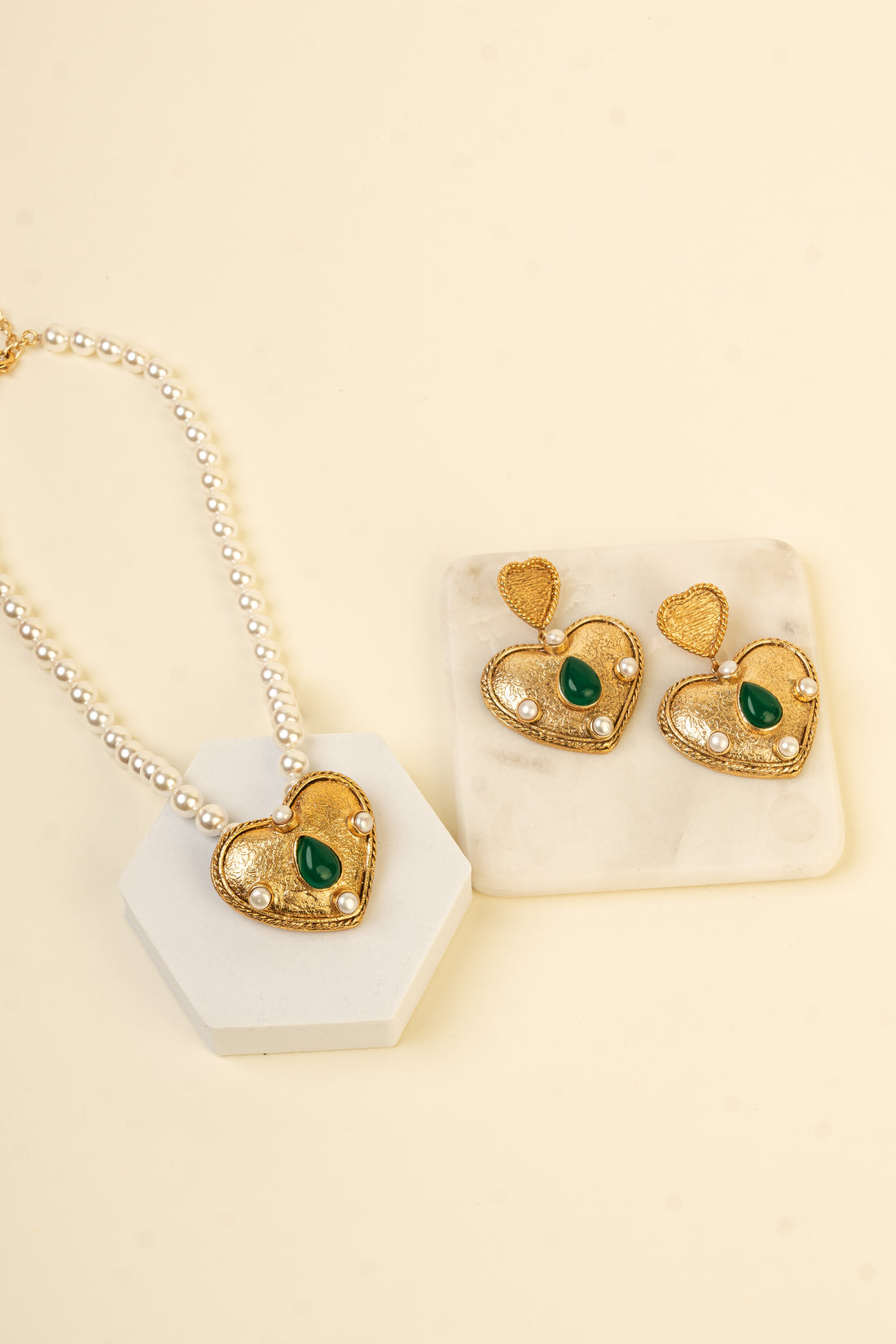 Baala Ethereal Heart Necklace with a pearl string band, gold heart pendant, and green gemstone.
