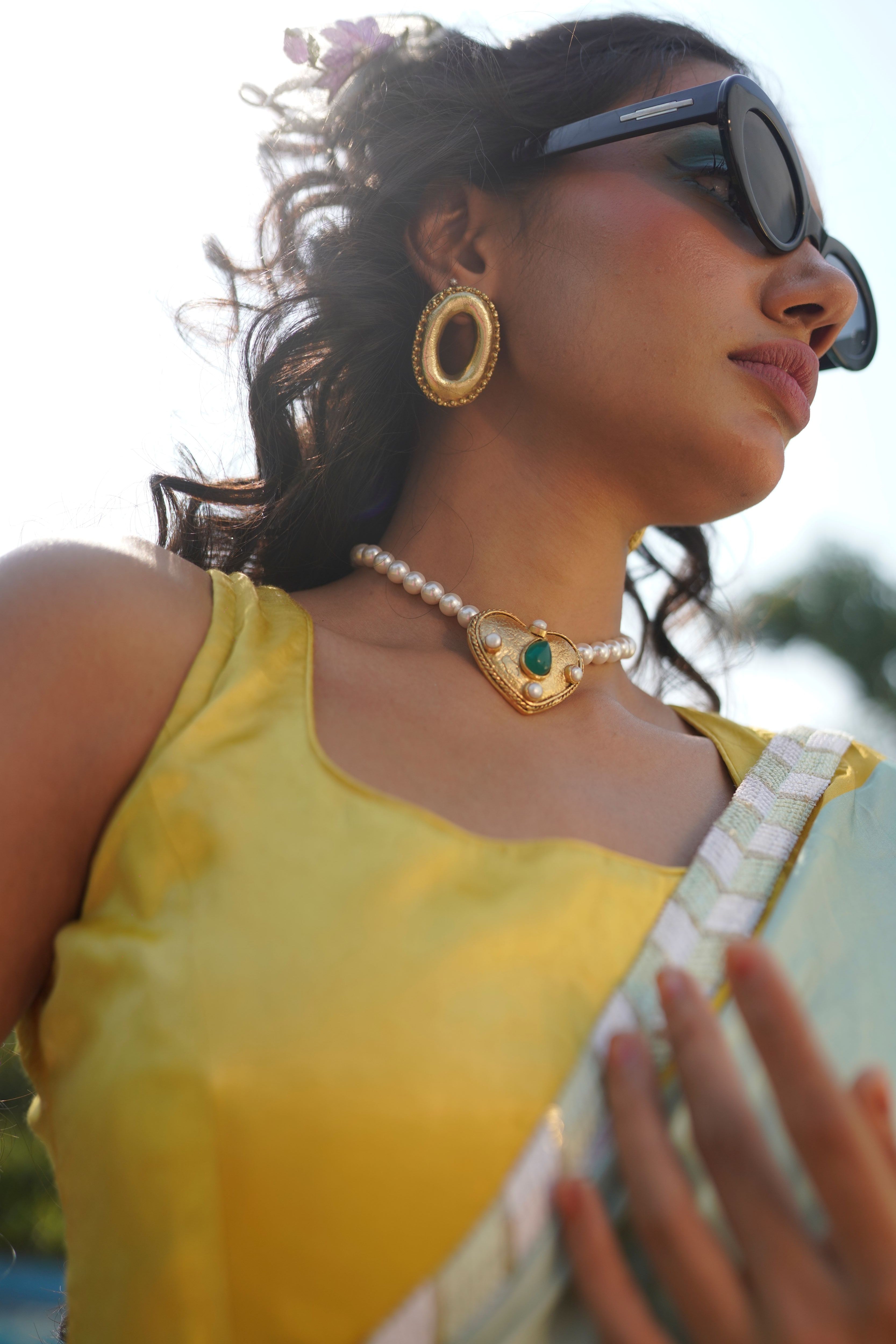 the gold-plated Ethereal Heart Necklace featuring white pearls and a green emerald stone pendant.