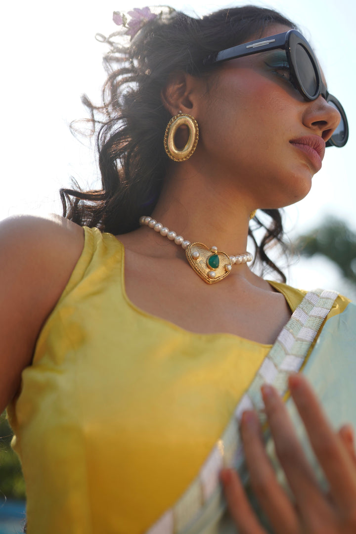 the gold-plated Ethereal Heart Necklace featuring white pearls and a green emerald stone pendant.