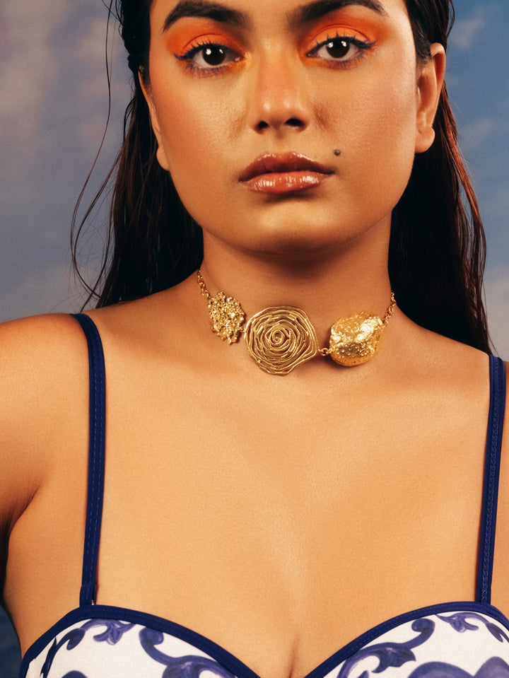 Woman wearing the BaalaJewels Flora gold-plated choker necklace with floral charms