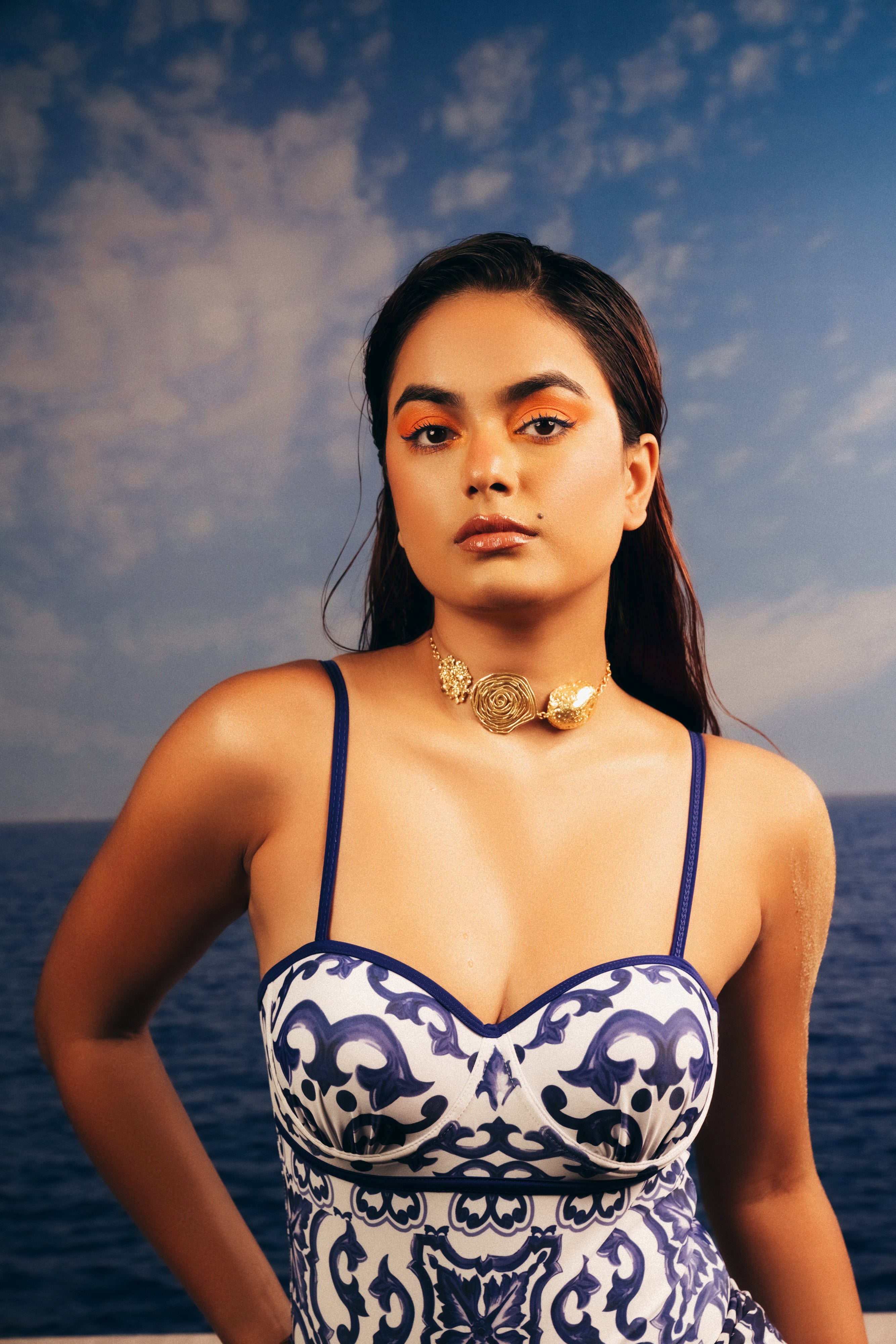 Model wearing a textured gold floral choker necklace.