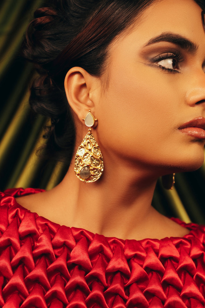 Woman wearing gold-plated Lustre Cascade drop earrings with intricate lattice design and gemstone details