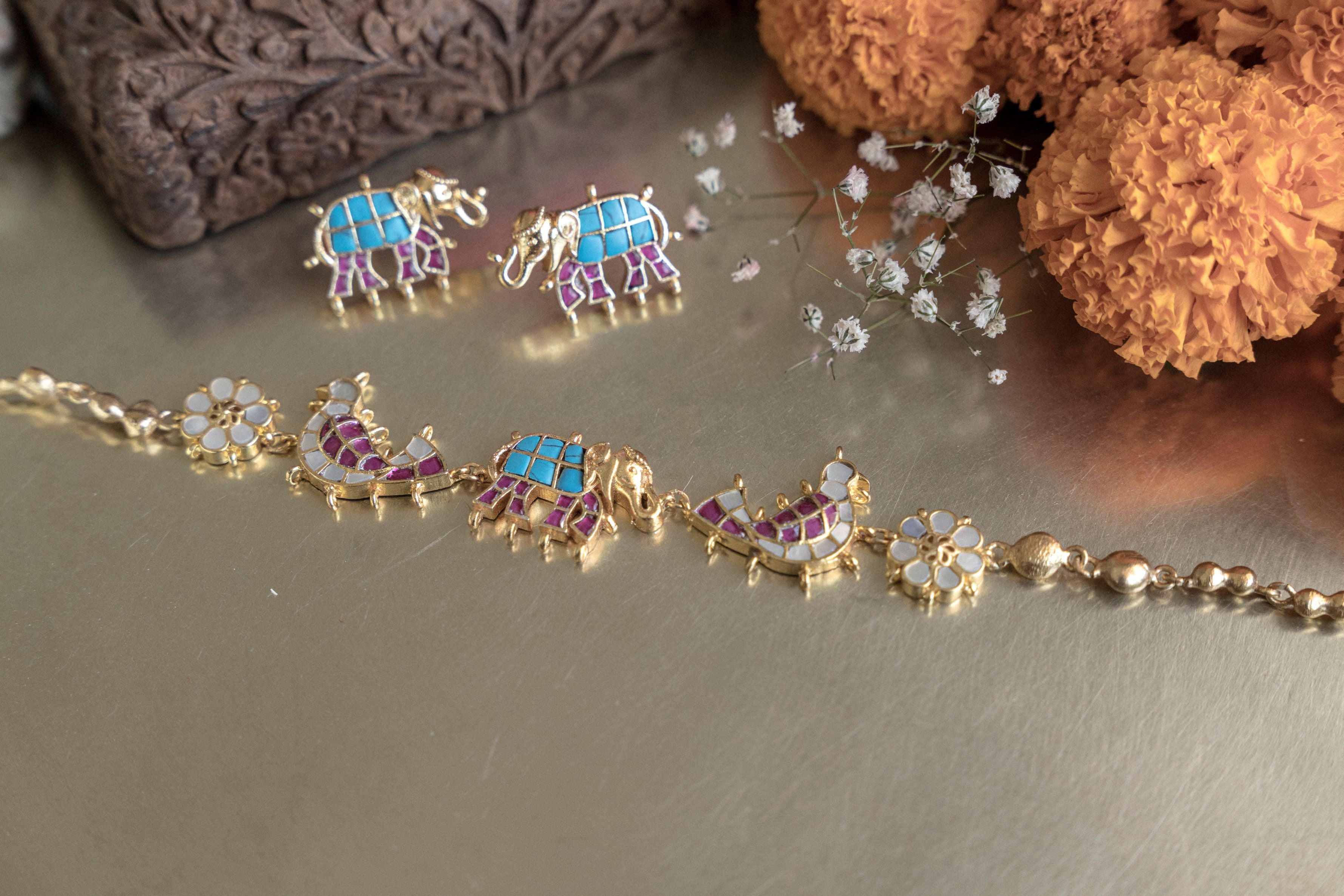 Gold-toned ethnic Haathi Kundan statement necklace with intricate enamel elephant charms and pearl chain styling.