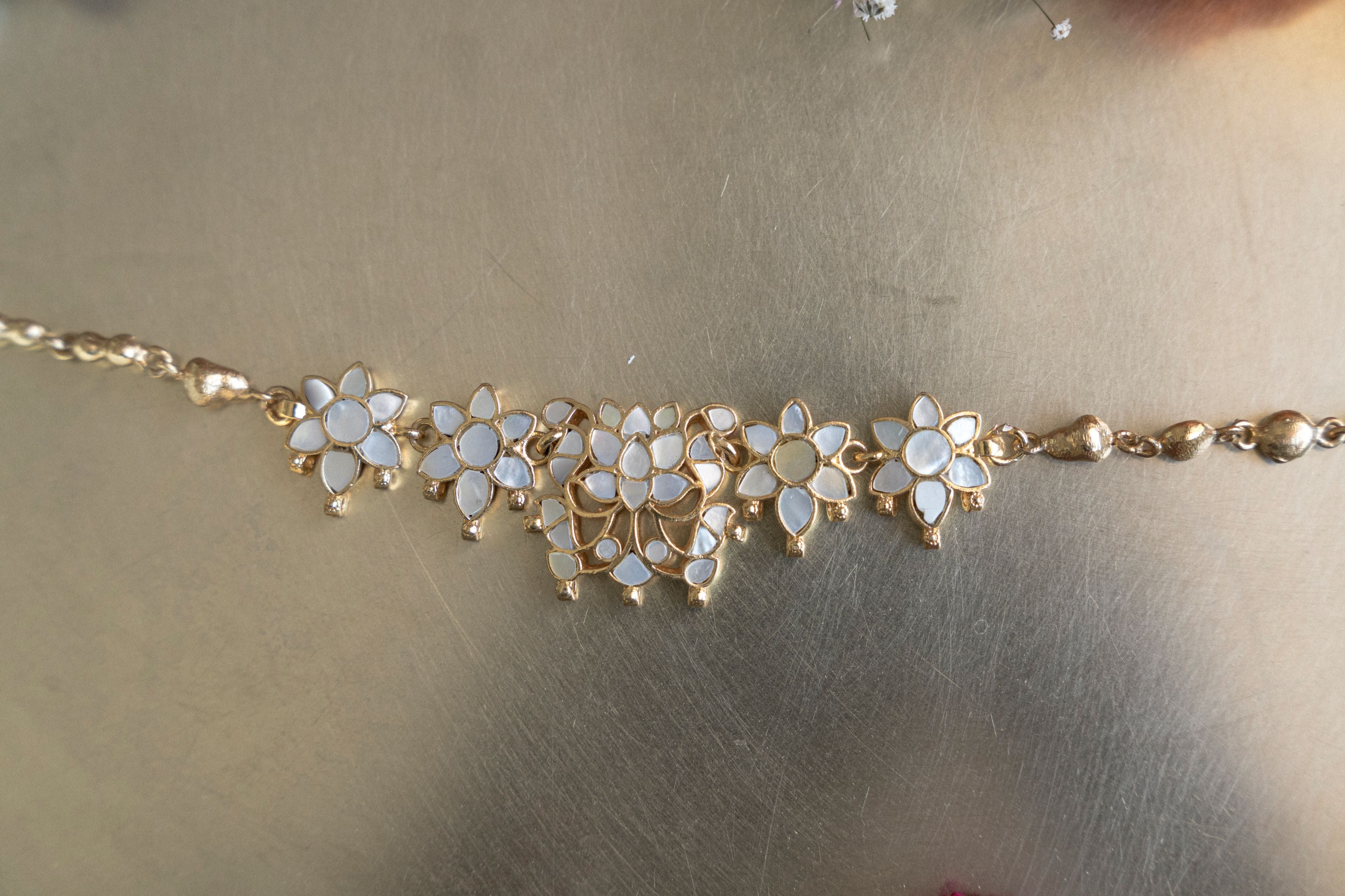 Intricate floral design mother of pearl choker necklace featuring lustrous flower motifs and matching studs.