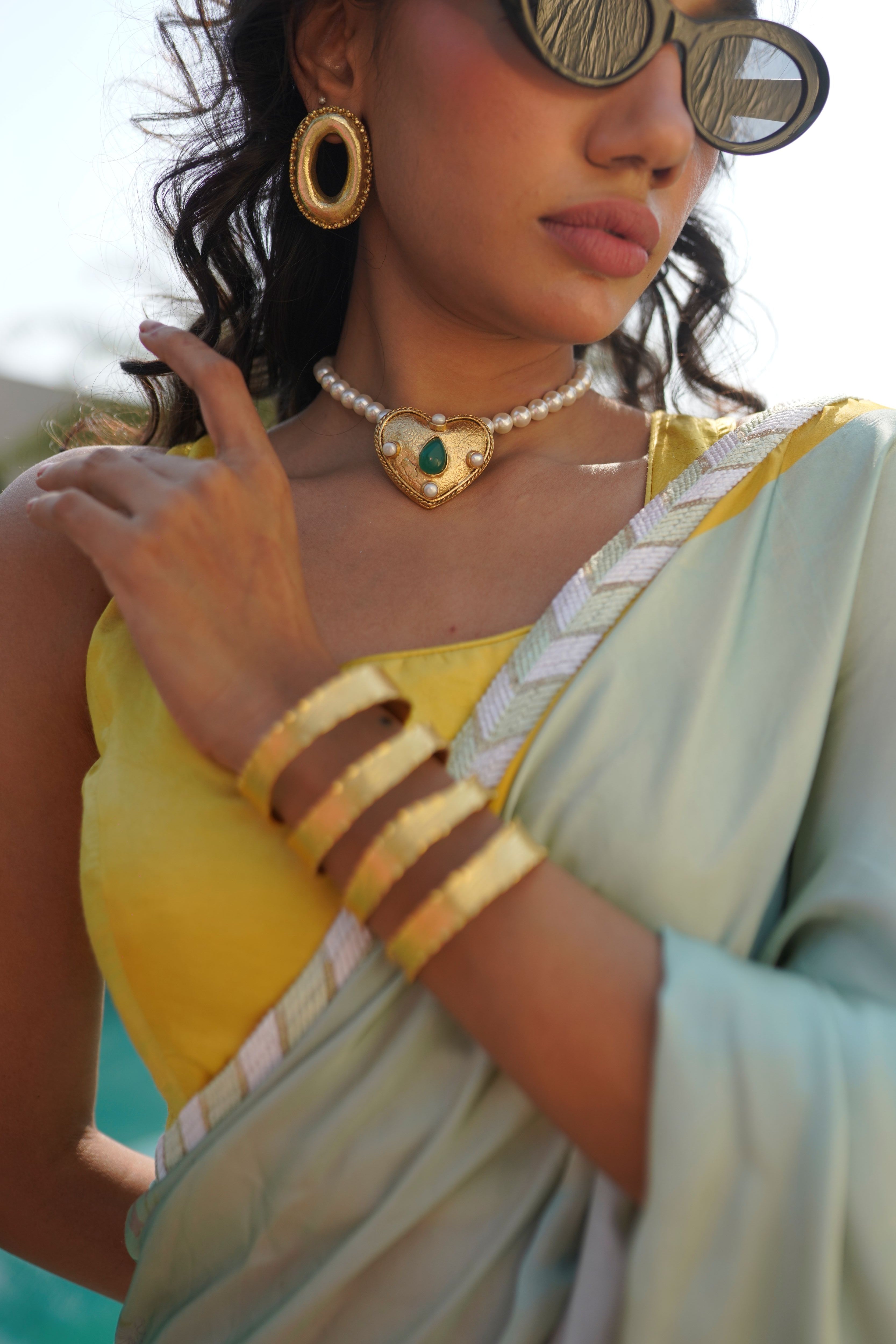 Ethically handmade 18k gold-plated heart necklace with green teardrop stone and pearl embellishments.