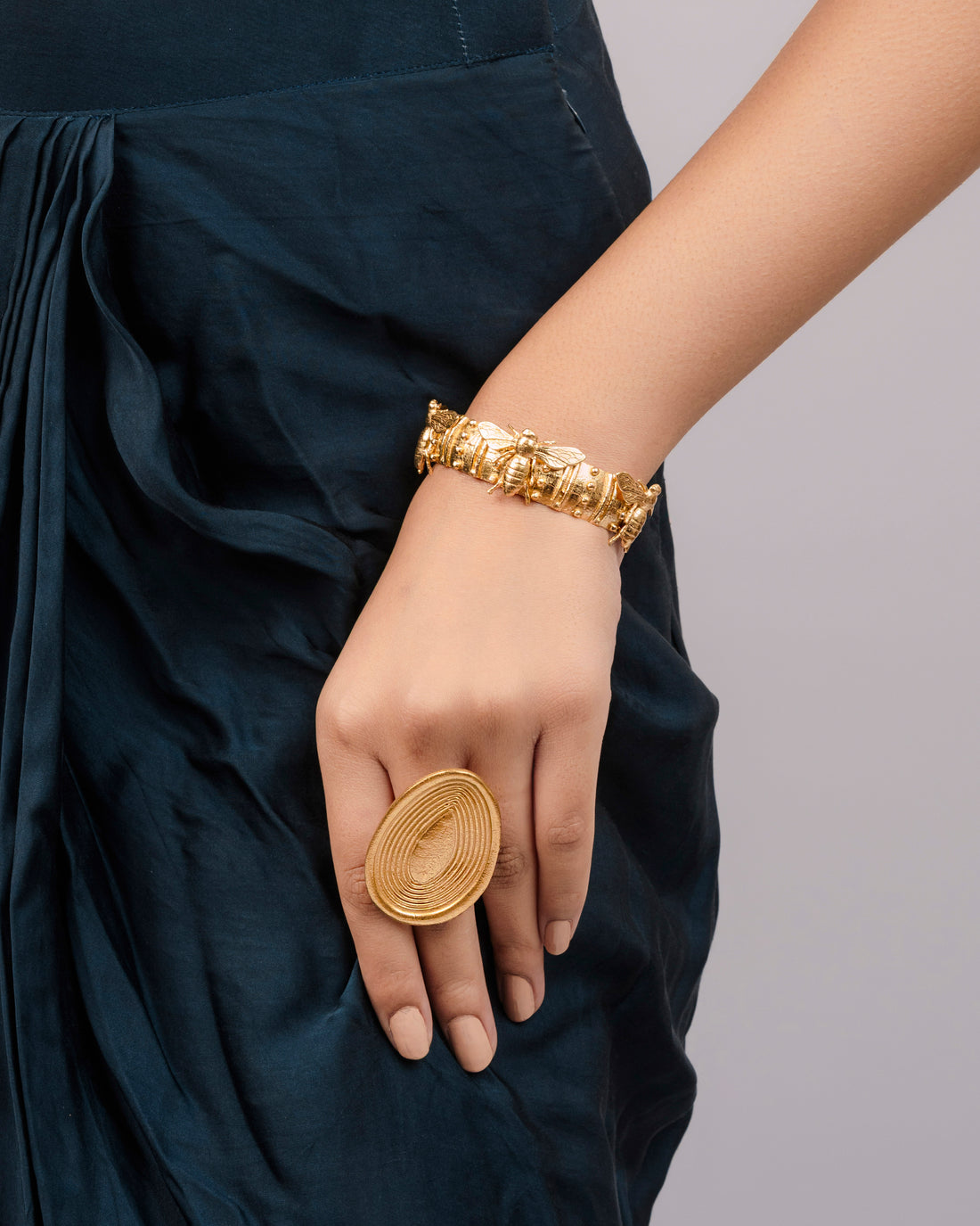 an adjustable 18k gold-plated brass cuff bracelet with textured honey bee design.