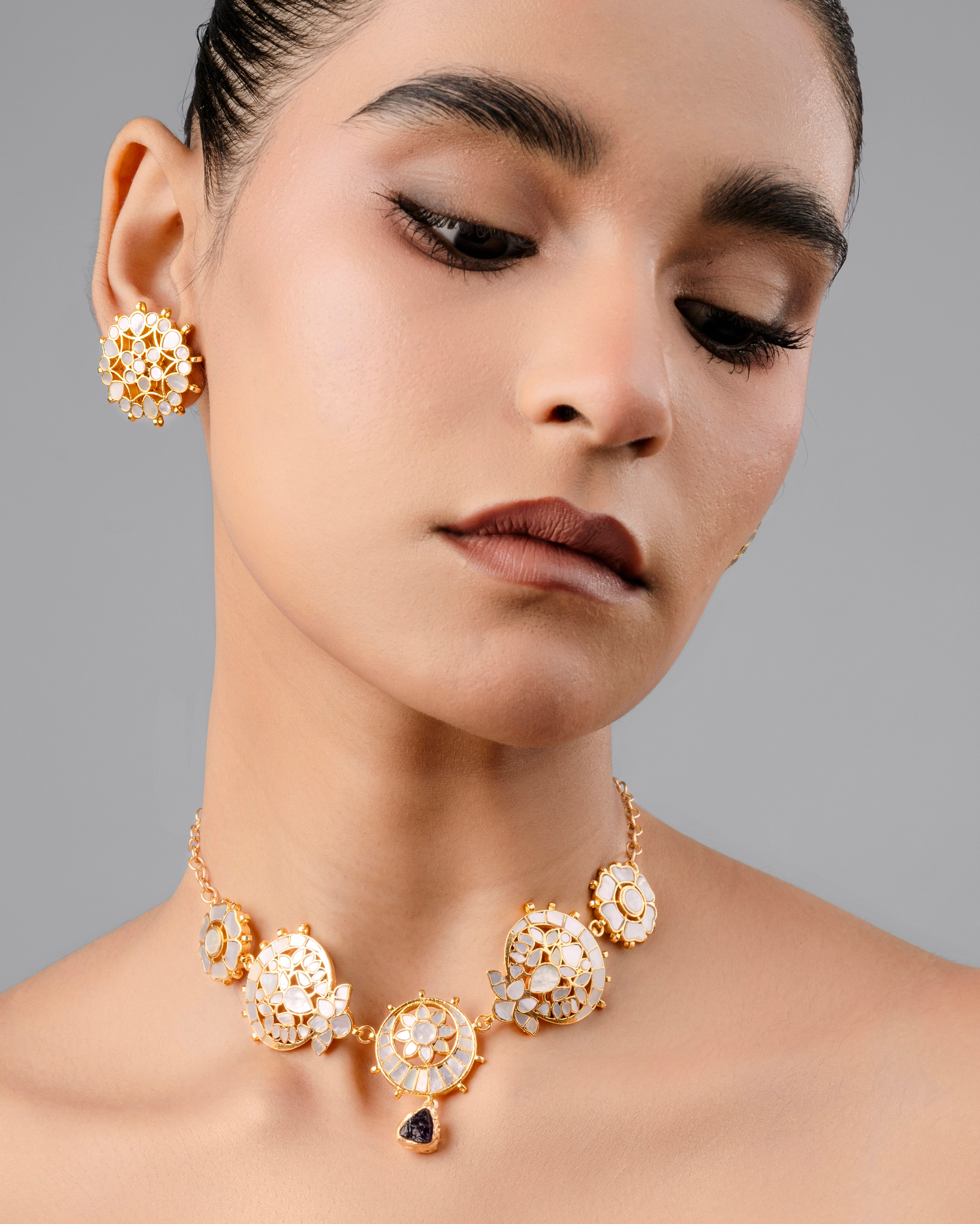 Handcrafted gold-plated mother-of-pearl choker necklace and matching stud earrings with traditional Kundan detailing and meenakari work.