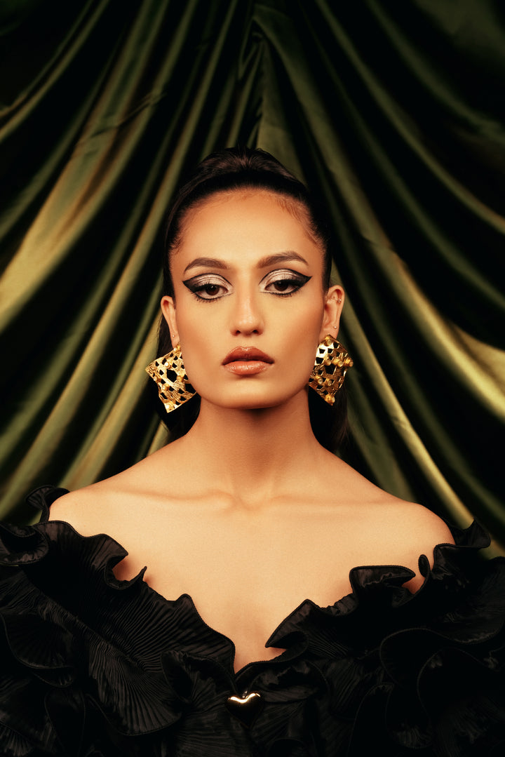 golden lattice drop earrings with geometric cutout details, worn with a black formal dress.