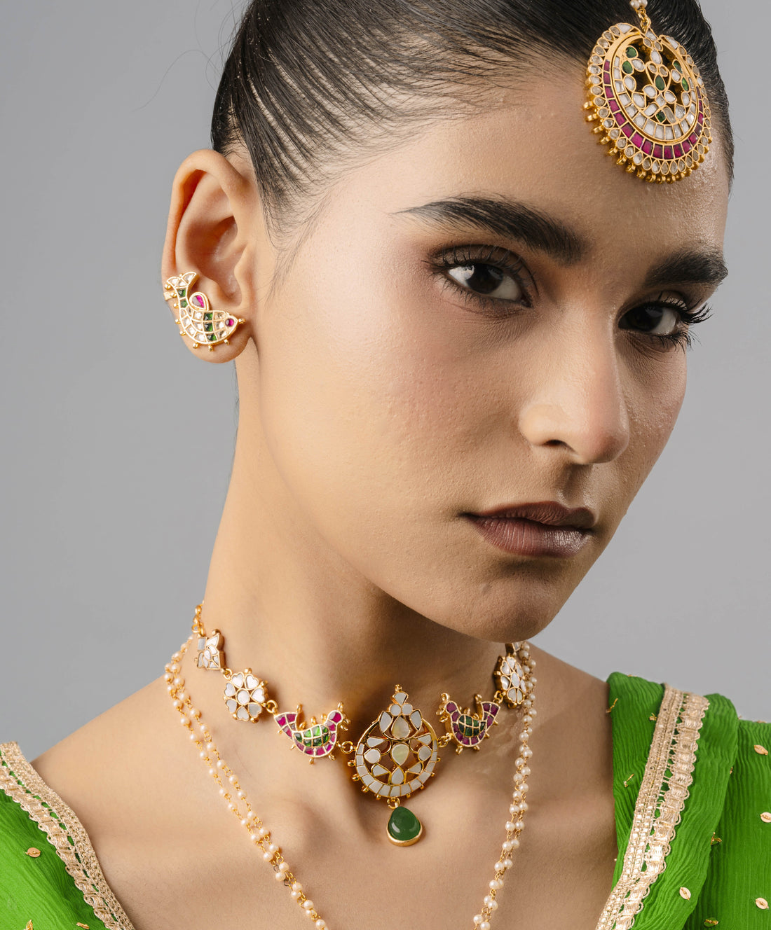 modern gold fish-shaped ear cuff with intricate scales, styled with a traditional green saree.