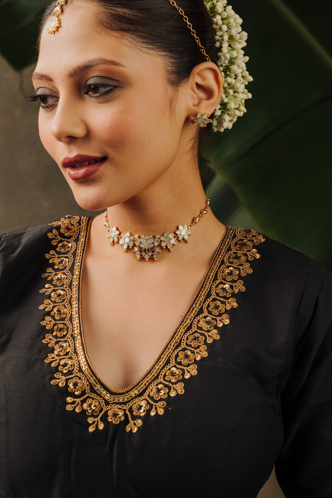 Elegant mother of pearl phool choker necklace with matching gold floral earrings.