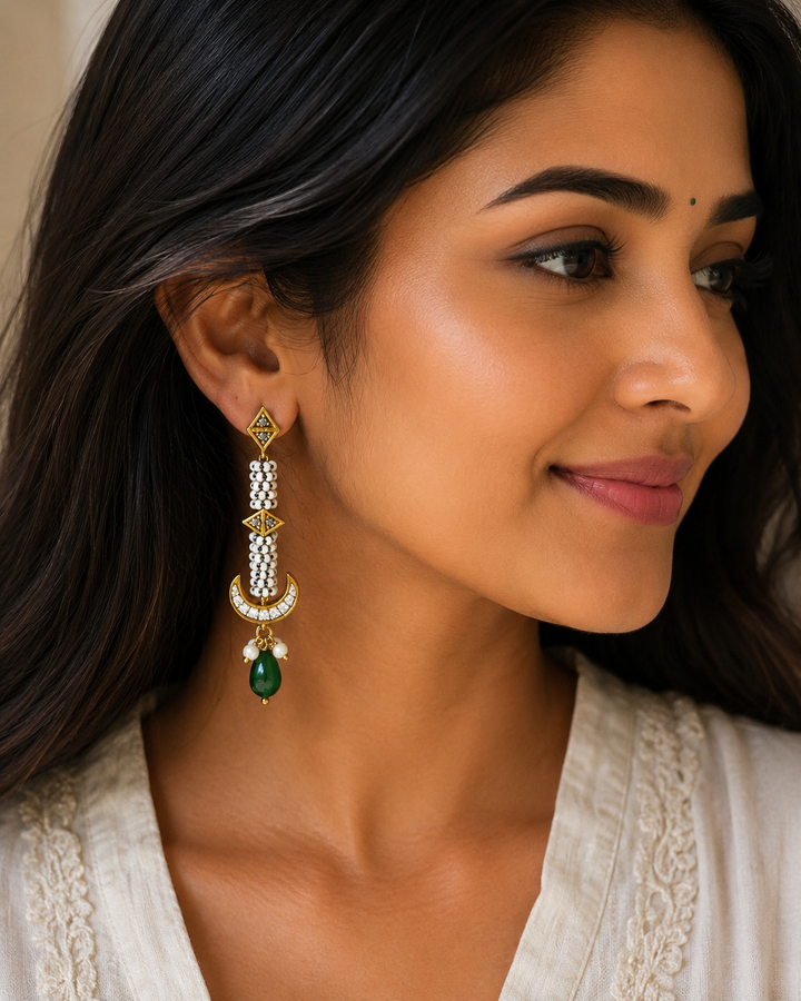 Gold-plated Kundan dangle earrings featuring striped pearl bead details, meenakari accents, and a green gemstone drop.