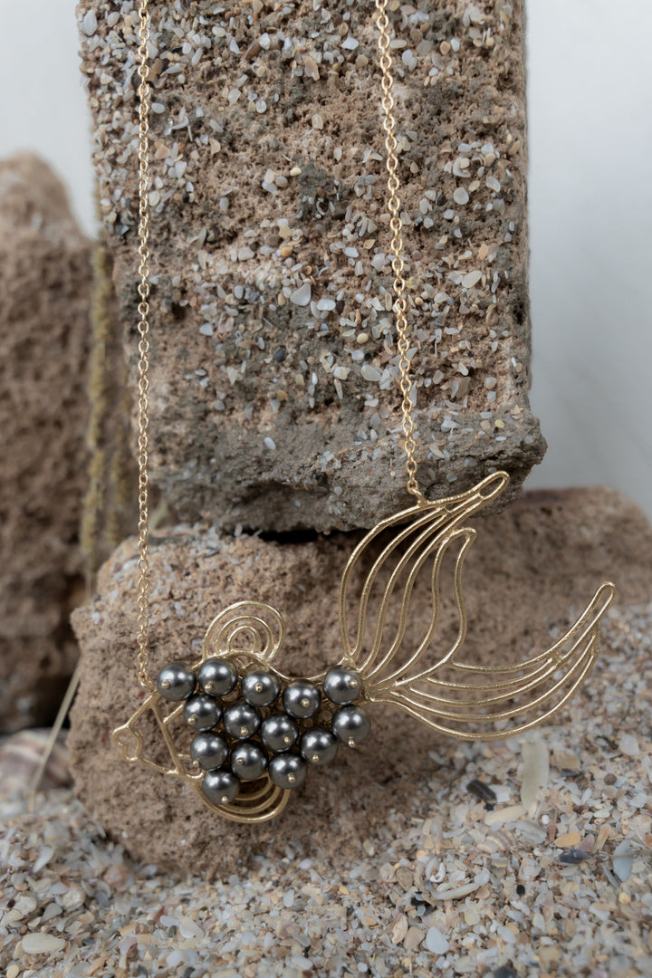 Gold wirework fish pendant necklace featuring a cluster of dark grey pearl accents