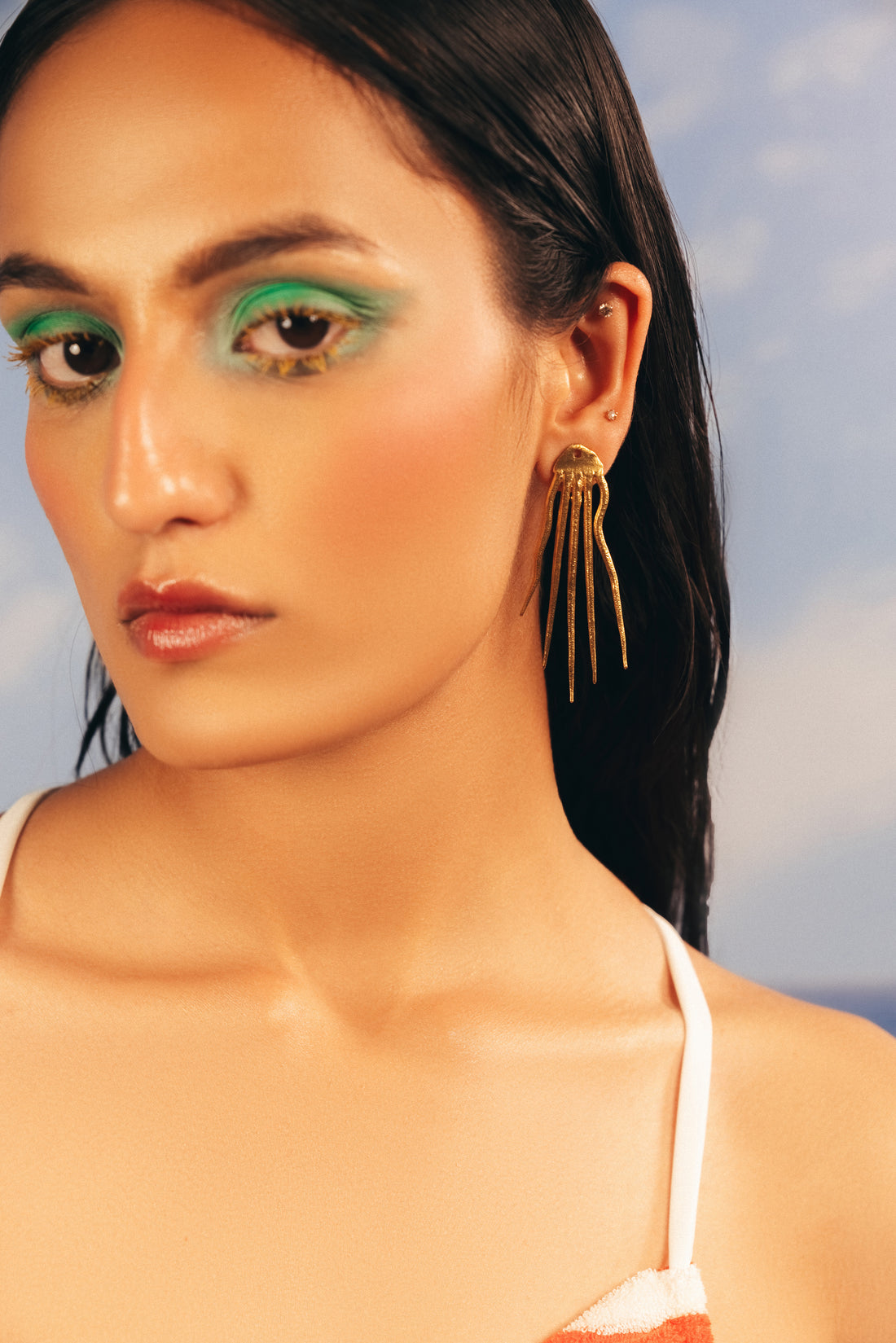 high-volume hairstyle wearing gold-plated octopus statement earrings of baala jewels