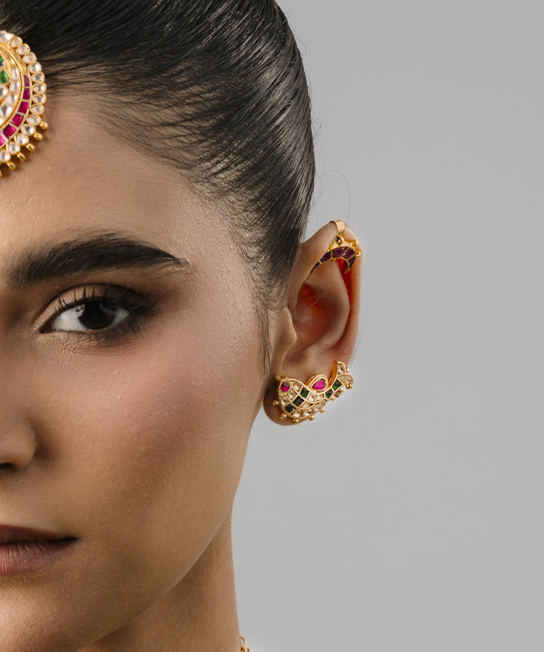 Minimalist yet striking fish-shaped gold ear cuff comfortably fitted on a female model, highlighting its lightweight design.