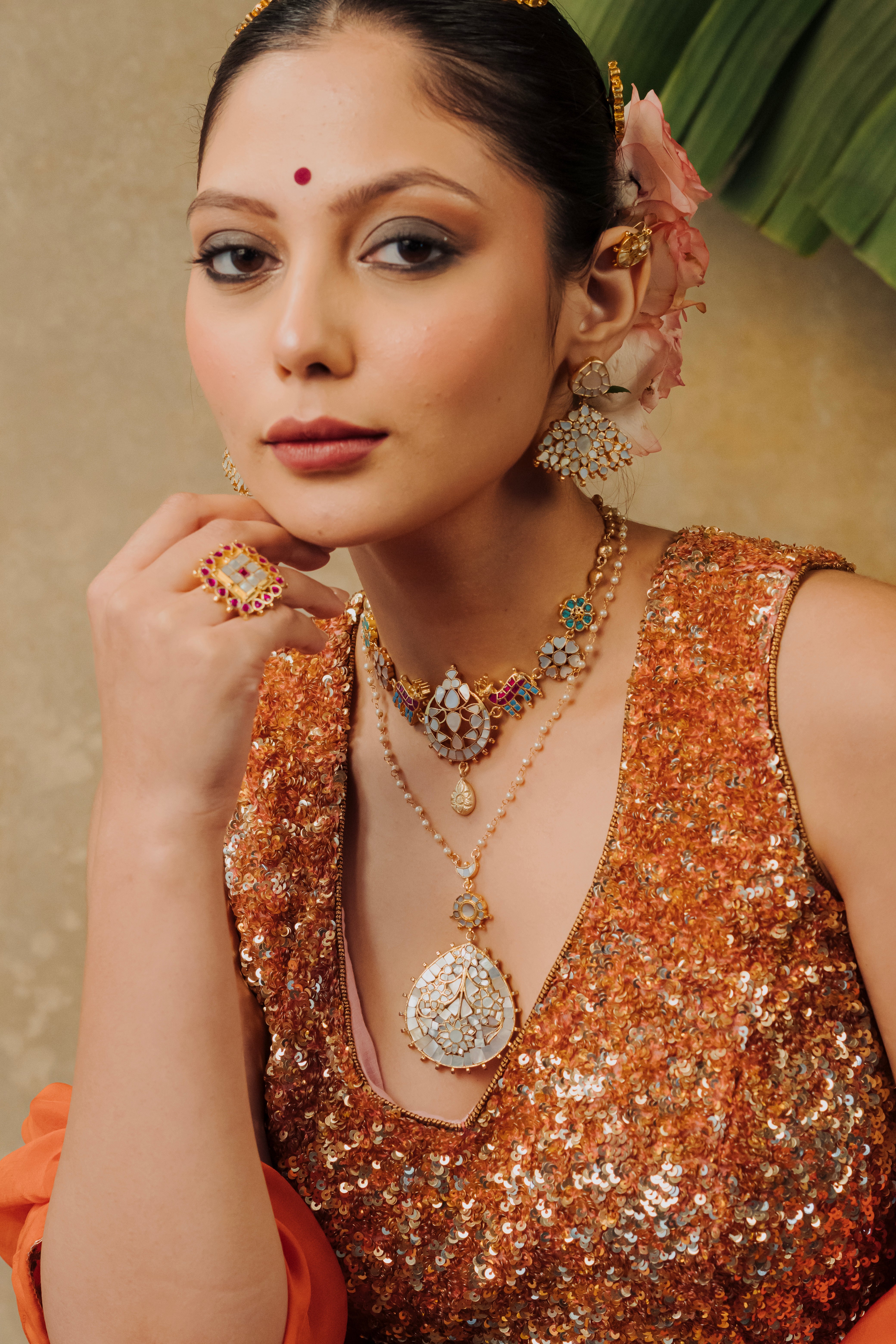 Side profile of woman styled in gold plated MOP drop necklace and 3-layered fan drop earrings