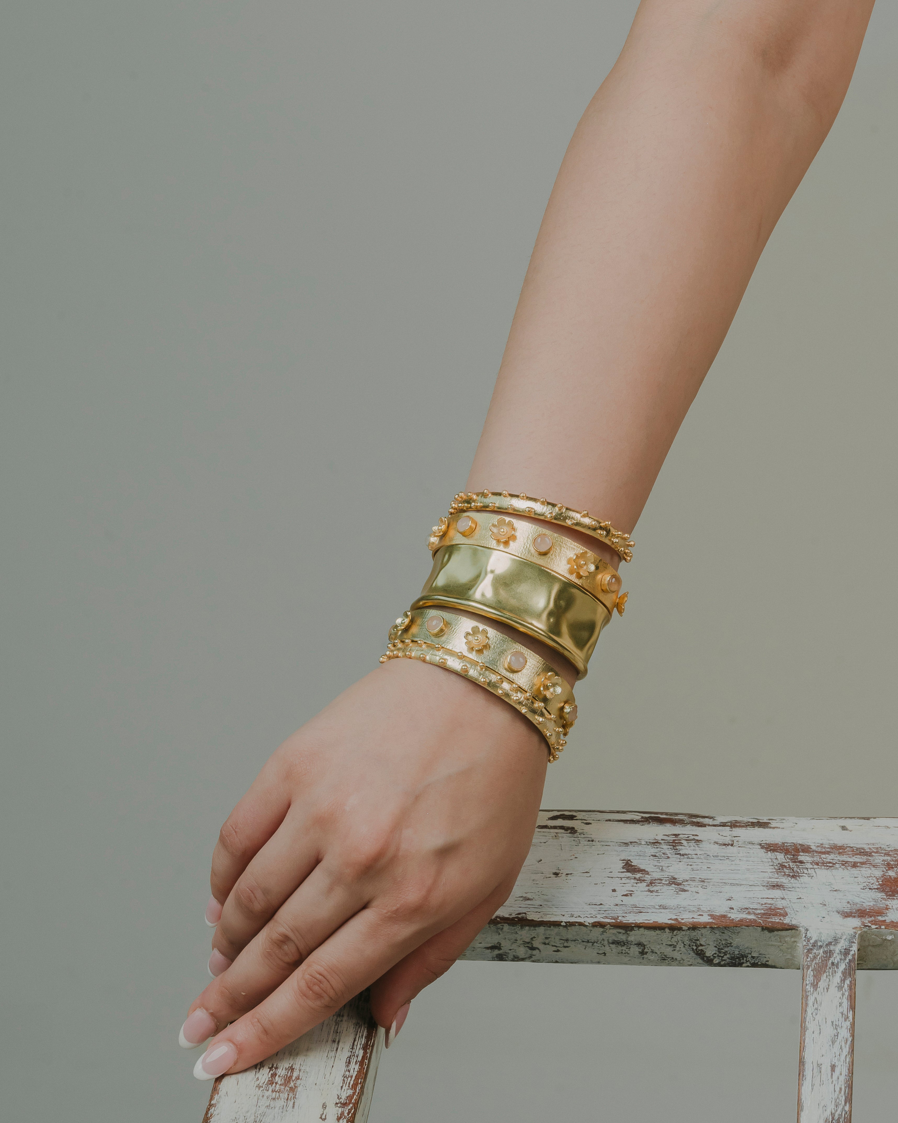 a stack of bold 18k gold-plated chunky bracelets with light pink stone. edgy, beautiful and best for ethenic and bold partywear look.