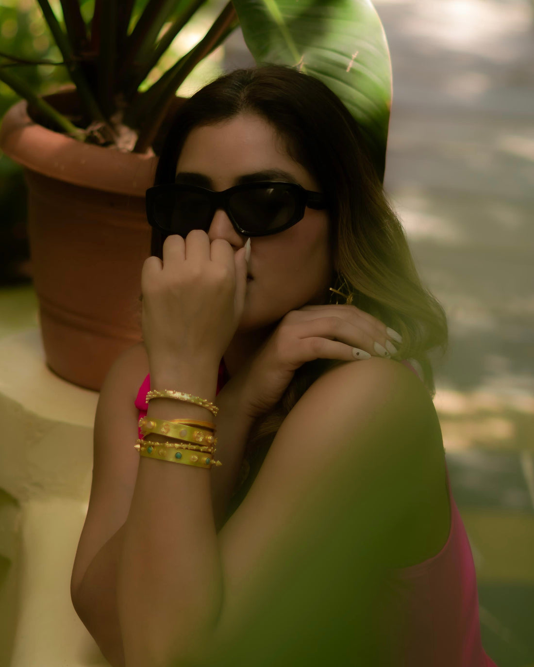 Model wearing 18k gold plated stacked kadas with turquoise stone details on wrist