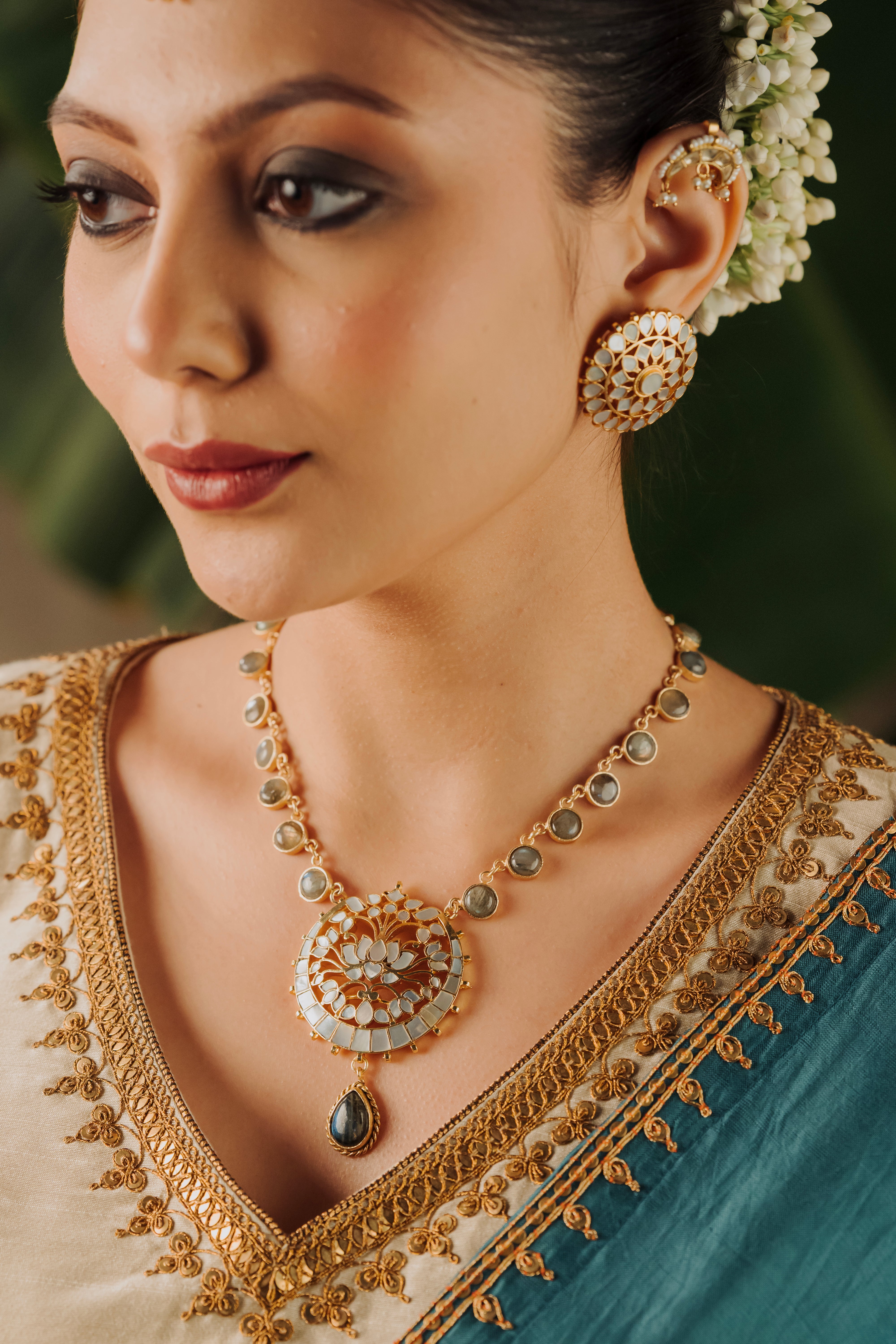 Woman wearing traditional gold-plated lotus pendant temple necklace with a bridal outfit