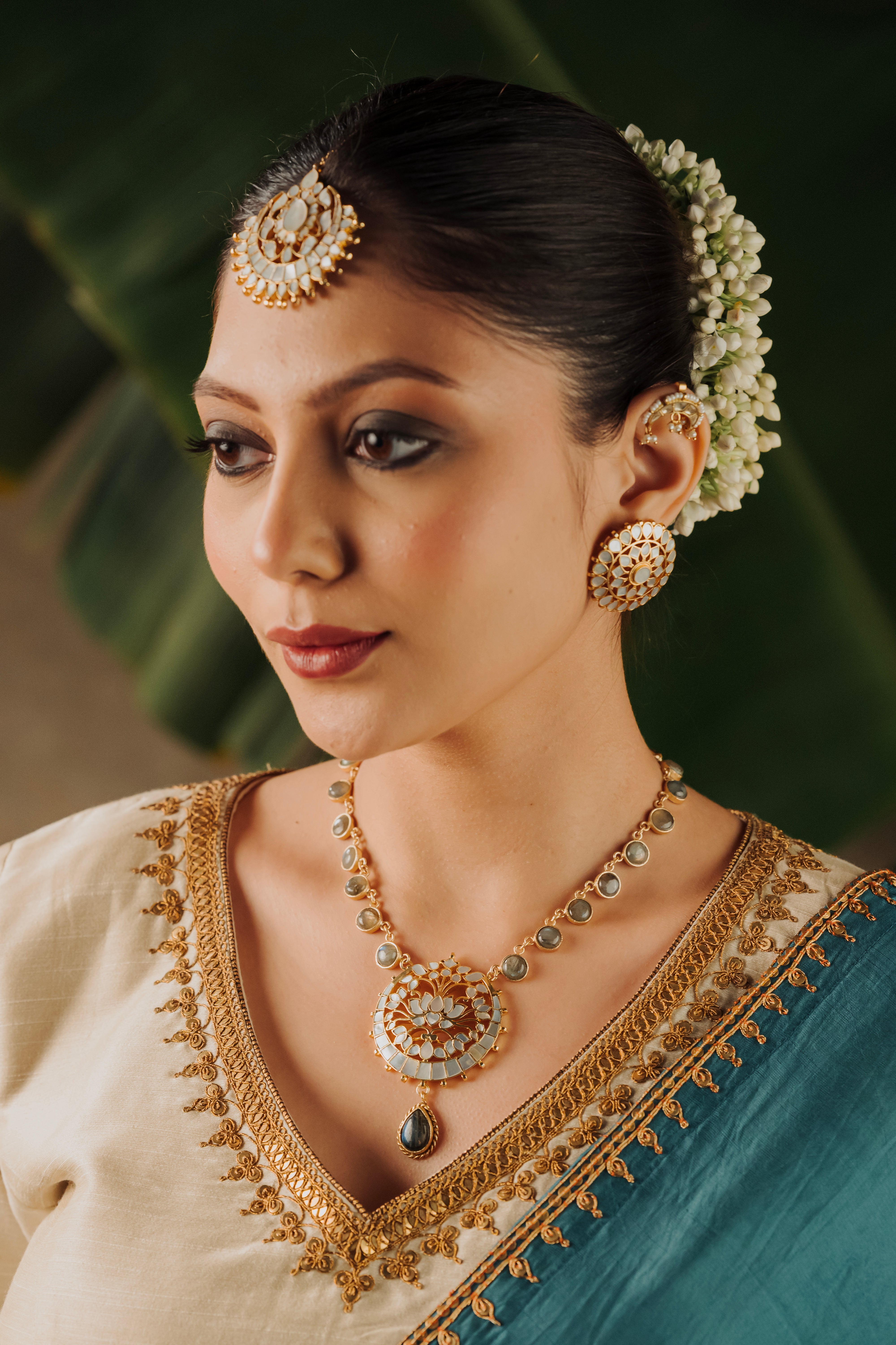 Indian bride styled in a traditional lotus motif temple jewelry necklace with Mother of Pearl detailing
