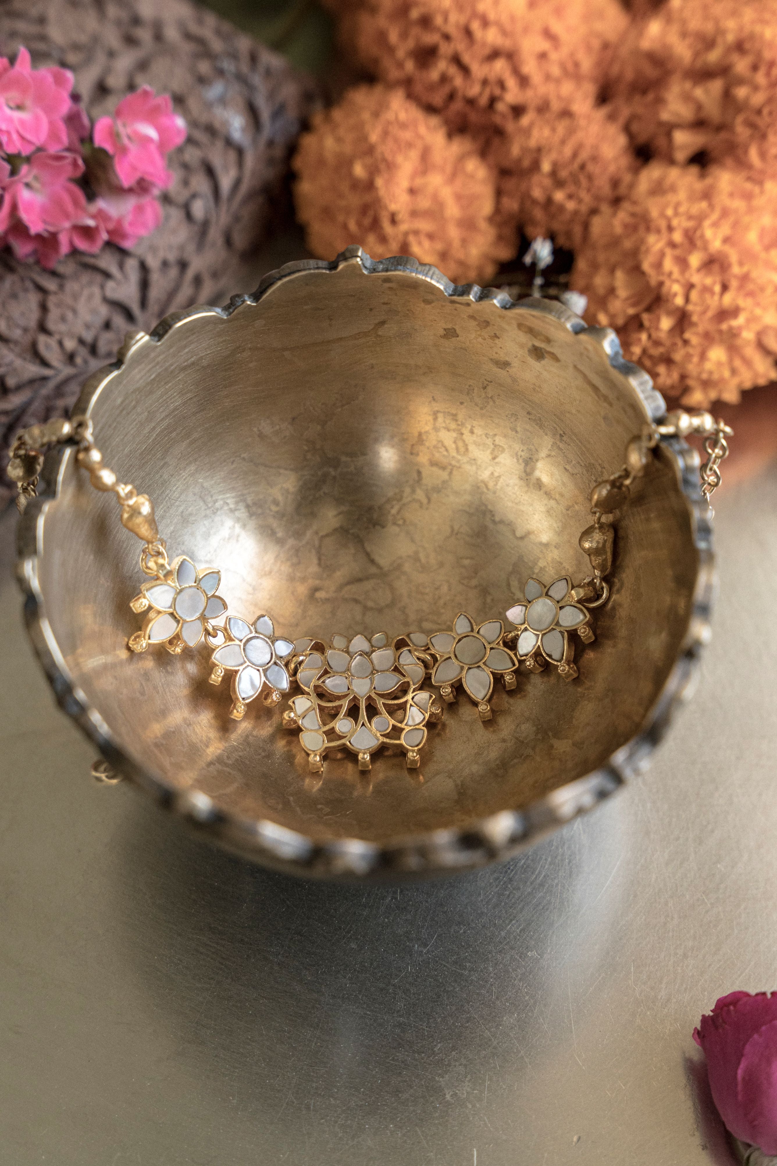 Gold floral choker set crafted with iridescent mother of pearl stones and complementary floral stud earrings.