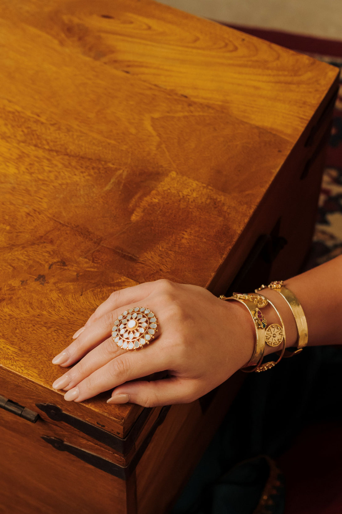 Traditional Indian gold-plated cocktail ring with round mother of pearl inlay work in a flower design.
