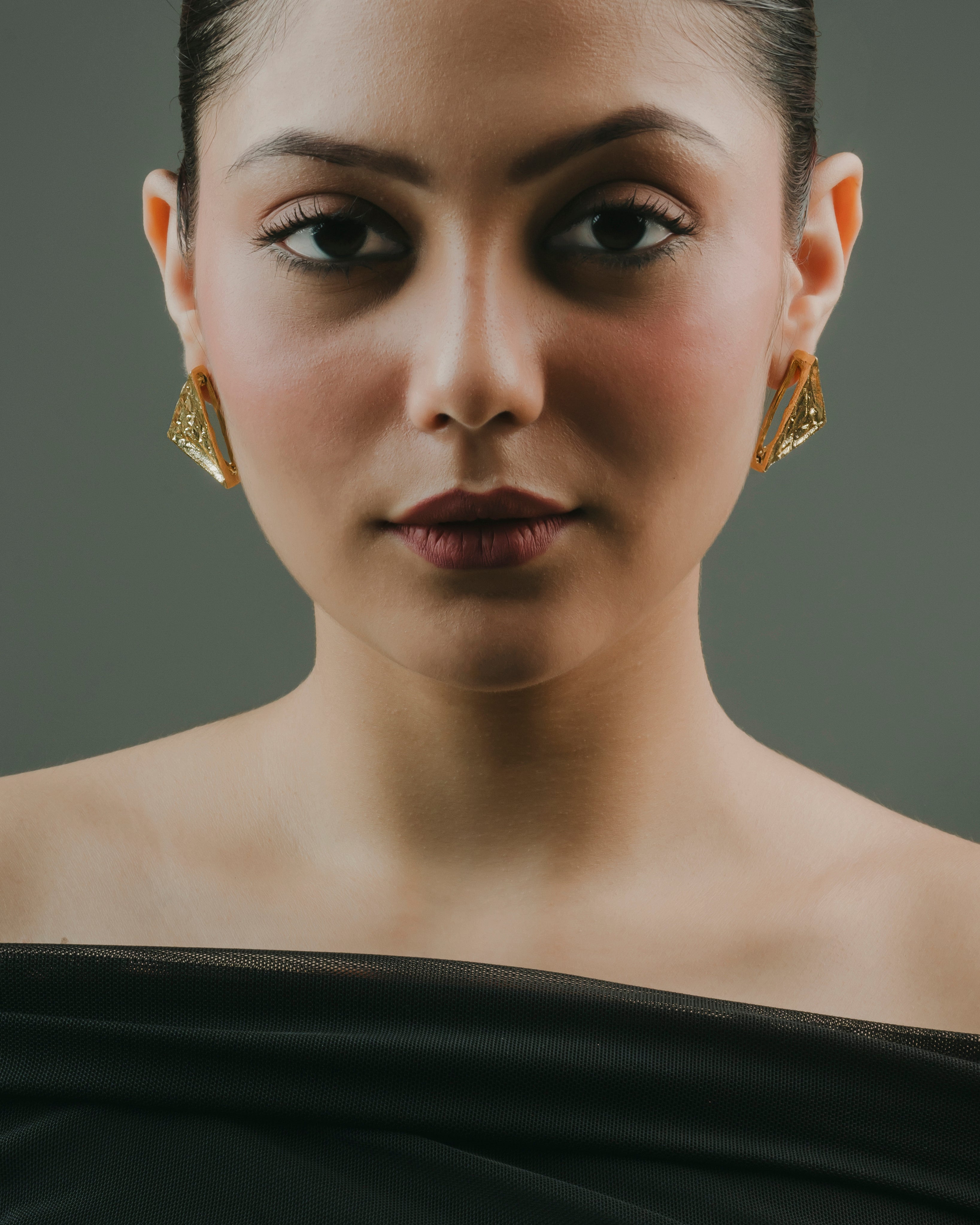 model styling gold-plated brass triangular drop earrings for party wear.