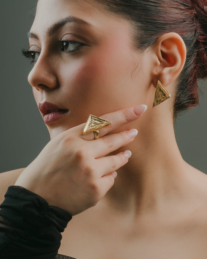 Modern geometric gold statement earring crafted from allergy-free brass shown on a model's ear.
