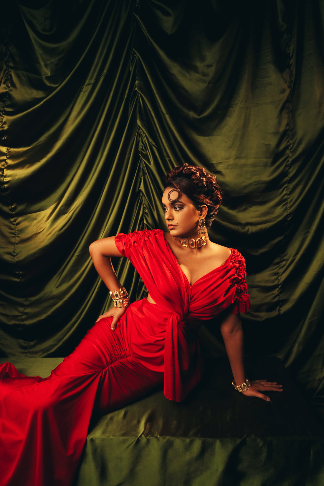 set of 2 openable gold-plated cuff bracelets adorned with turquoise and green stones, styled with a red evening outfit.