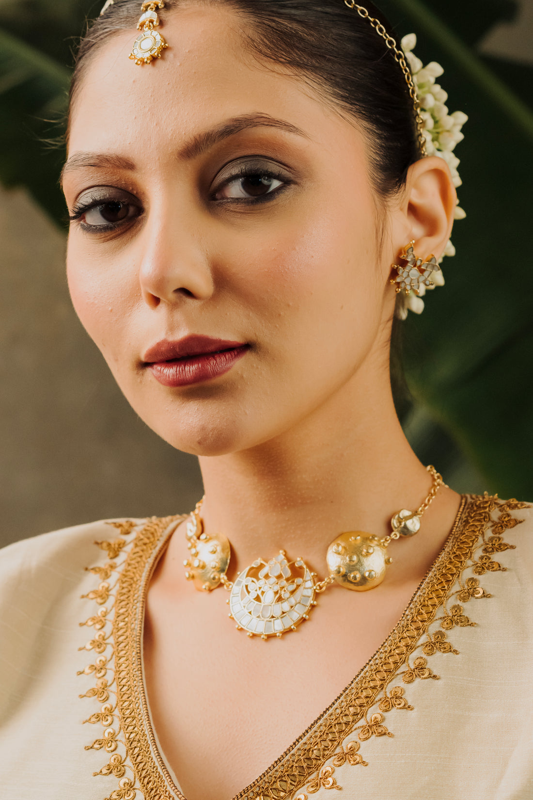 Statement gold choker necklace with raised beaded textured discs and mother of pearl moon design.