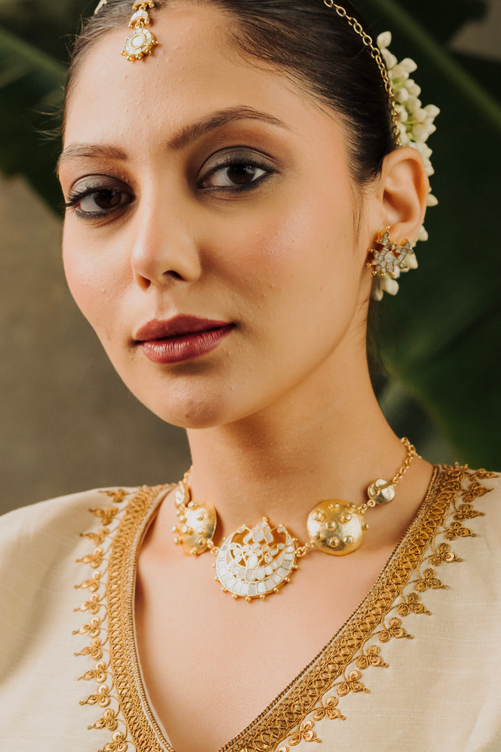 Statement gold choker necklace with raised beaded textured discs and mother of pearl moon design.