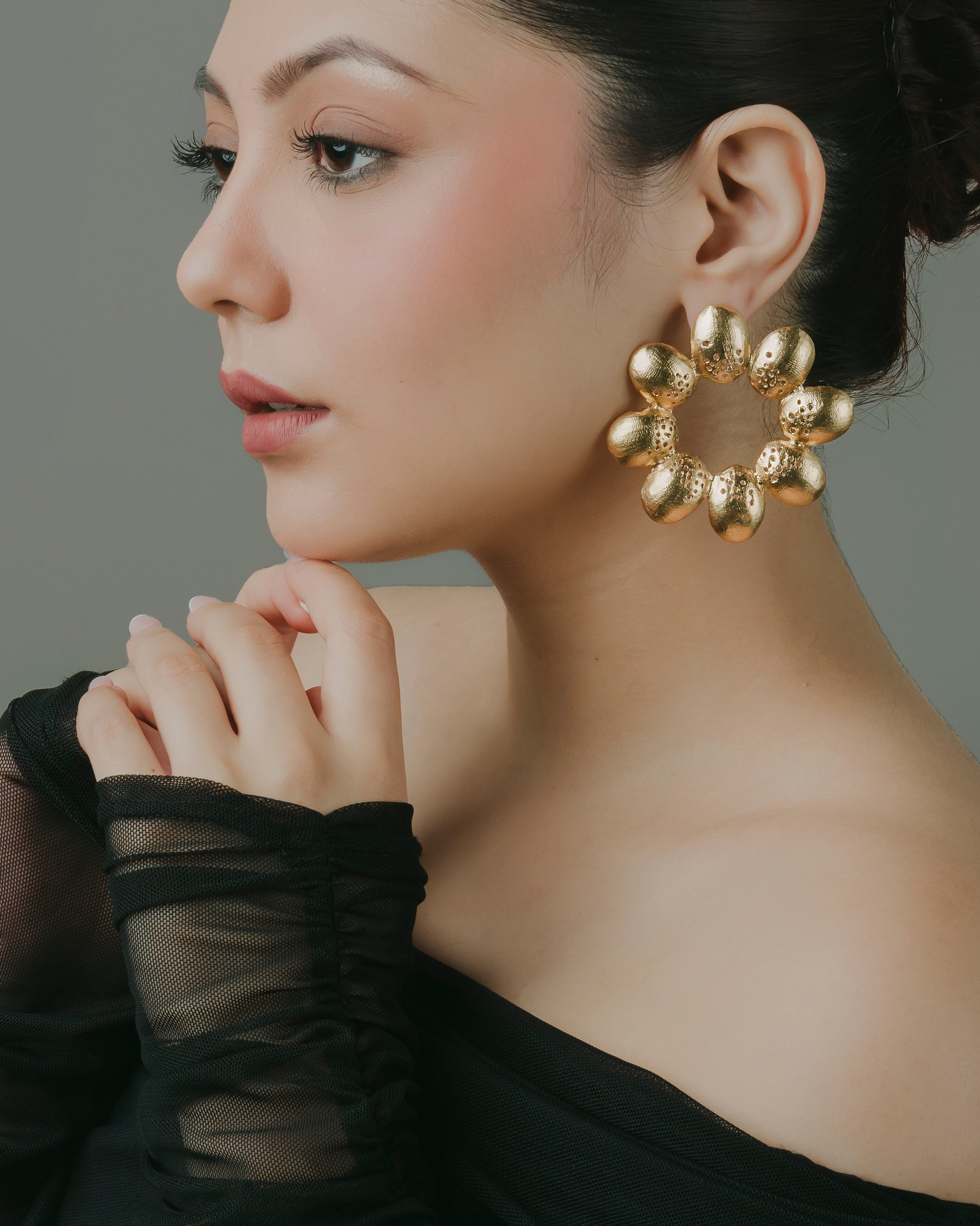 Chunky gold floral statement hoop earrings featuring handcrafted textured petal detailing.