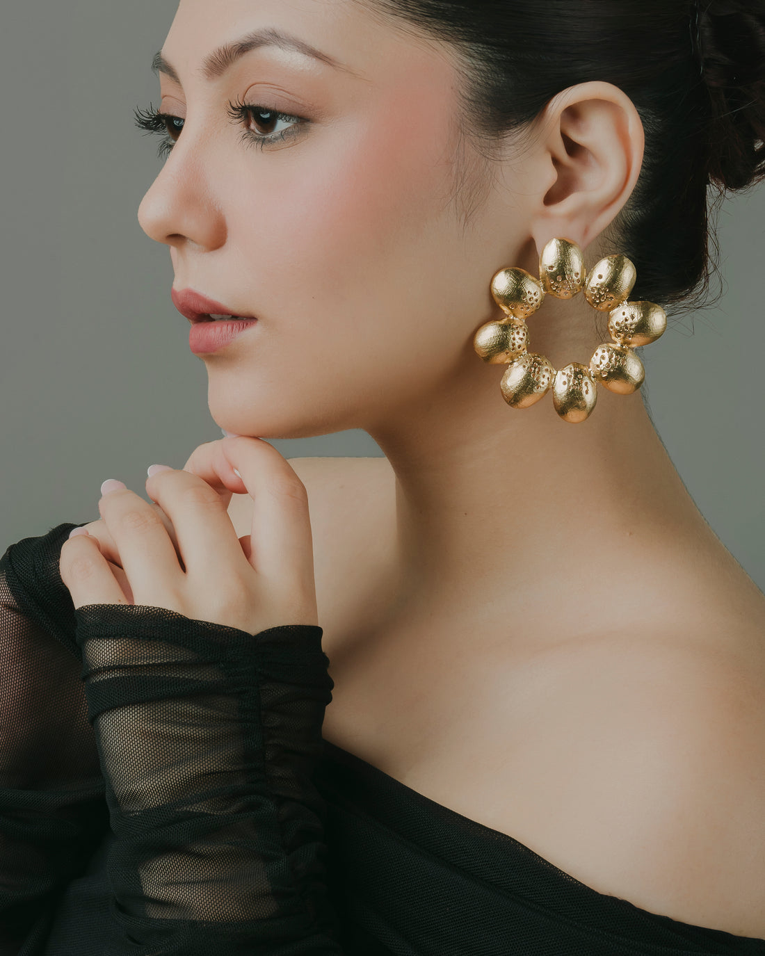 Chunky gold floral statement hoop earrings featuring handcrafted textured petal detailing.