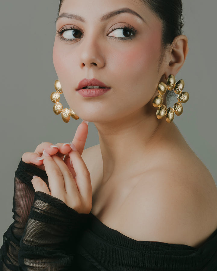 gold-toned leafy floral hoop earrings for party wear.