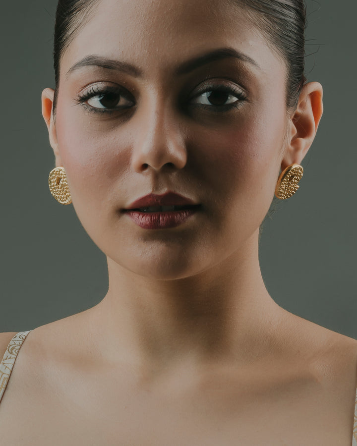 Skin-friendly gold-plated Coma Stud earrings worn by a baala jewels's model.