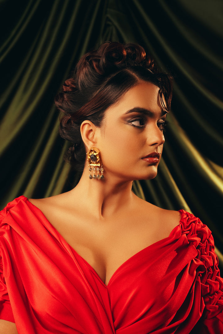 Ebon Eclat three-stone ruby zoisite gold dangle earrings shown on a model against a dark green backdrop