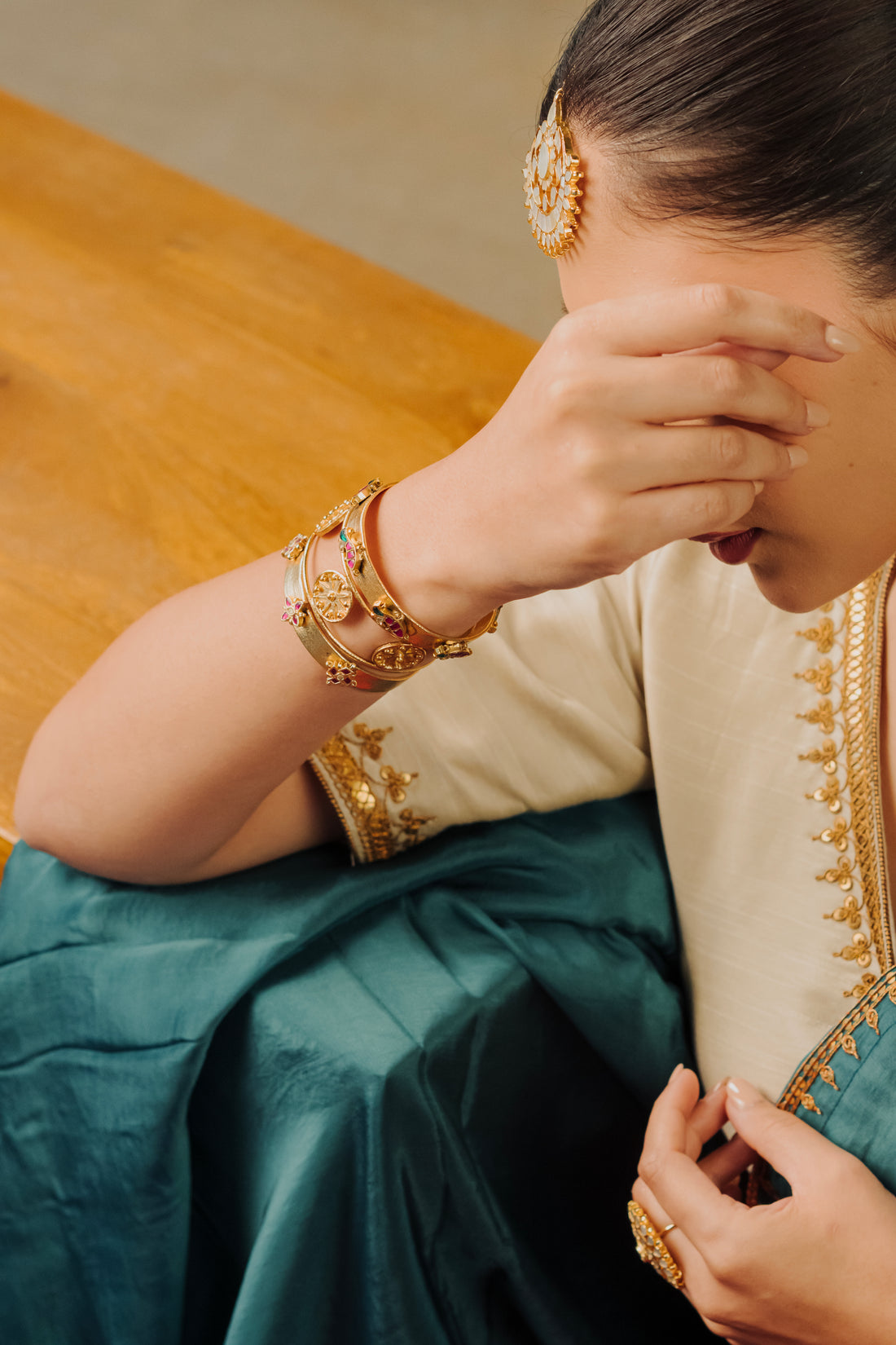 Set of 3 adjustable gold-plated ethnic bangles and kadas worn with traditional attire.