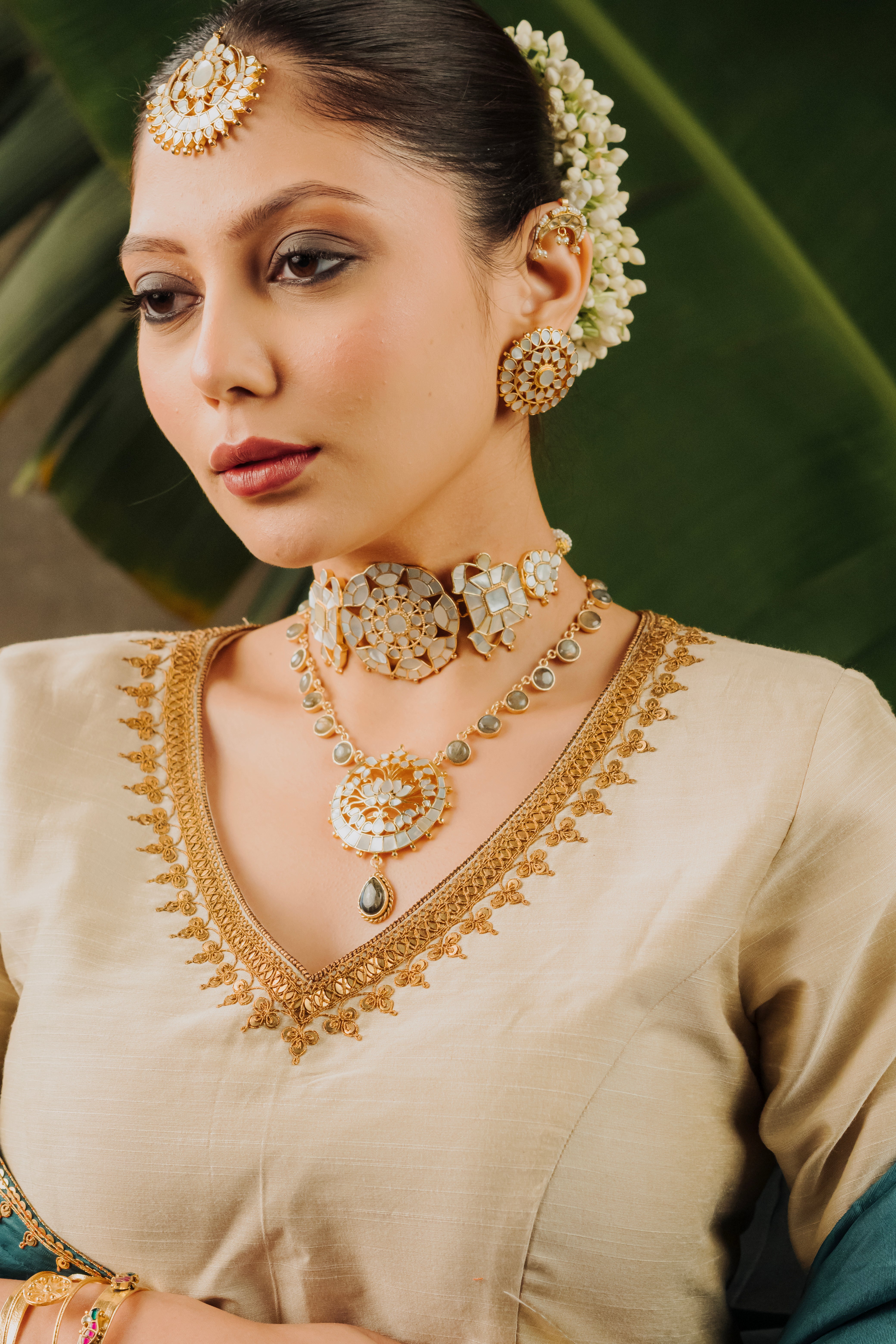 Genda Phool handmade brass alloy statement choker and floral stud earrings on model in ethnic wear