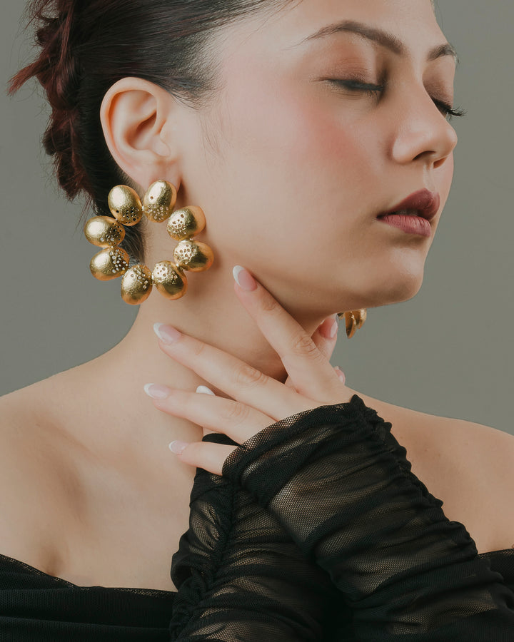 Handcrafted 18k gold-toned leafy floral hoop statement earrings worn with evening outfit.