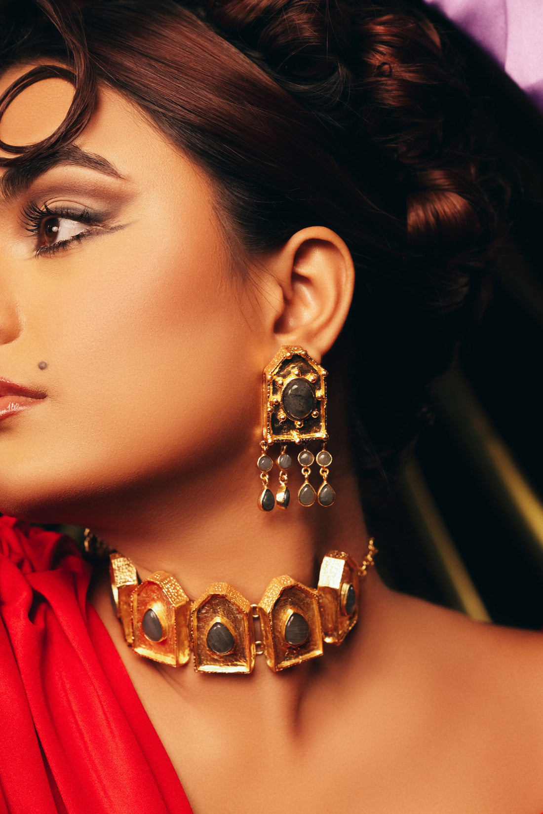 Woman in a red dress styled with handcrafted 18k gold-plated statement drop earrings