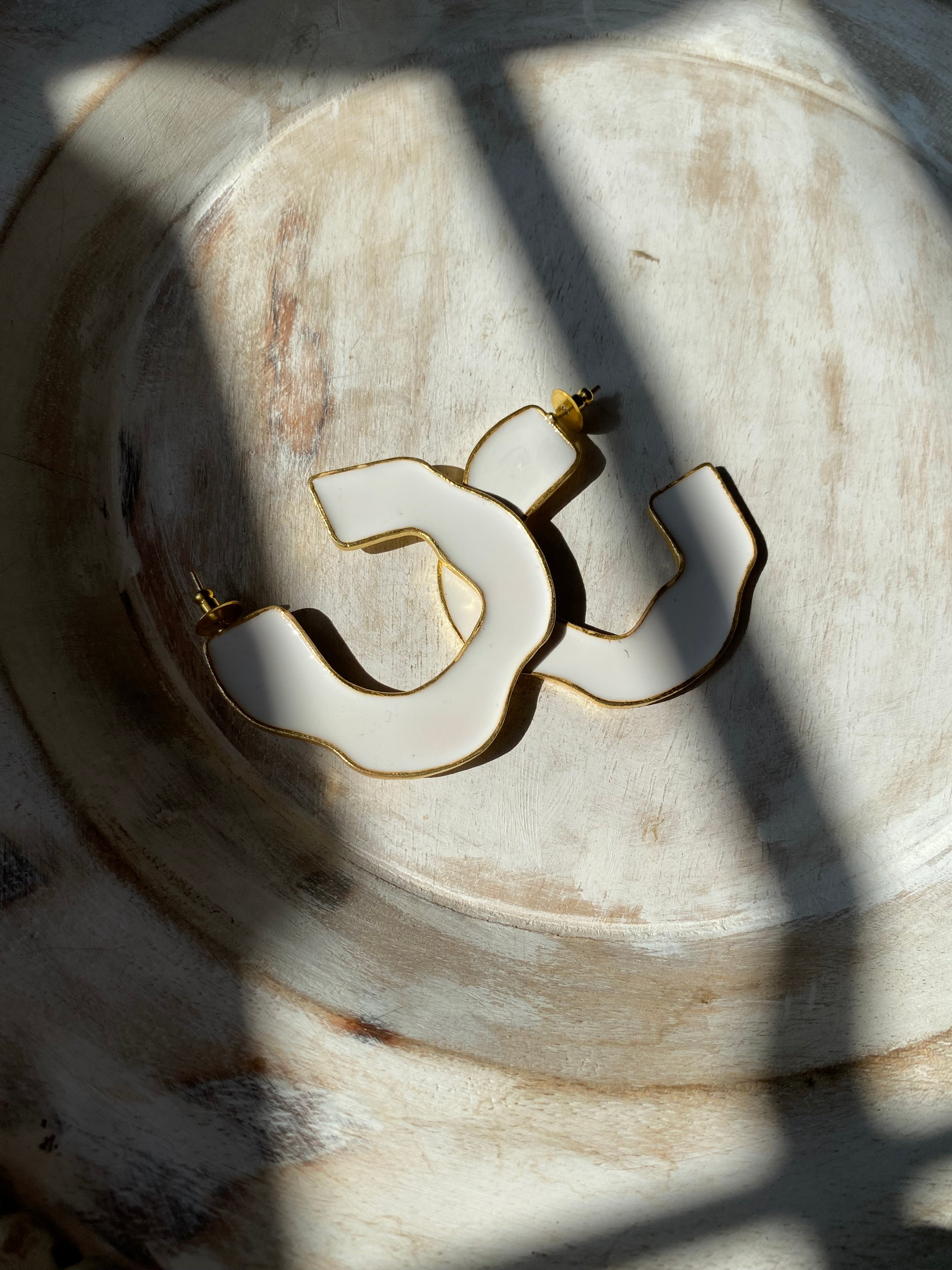 handcrafted white statement hoop earrings with gold metal accents.