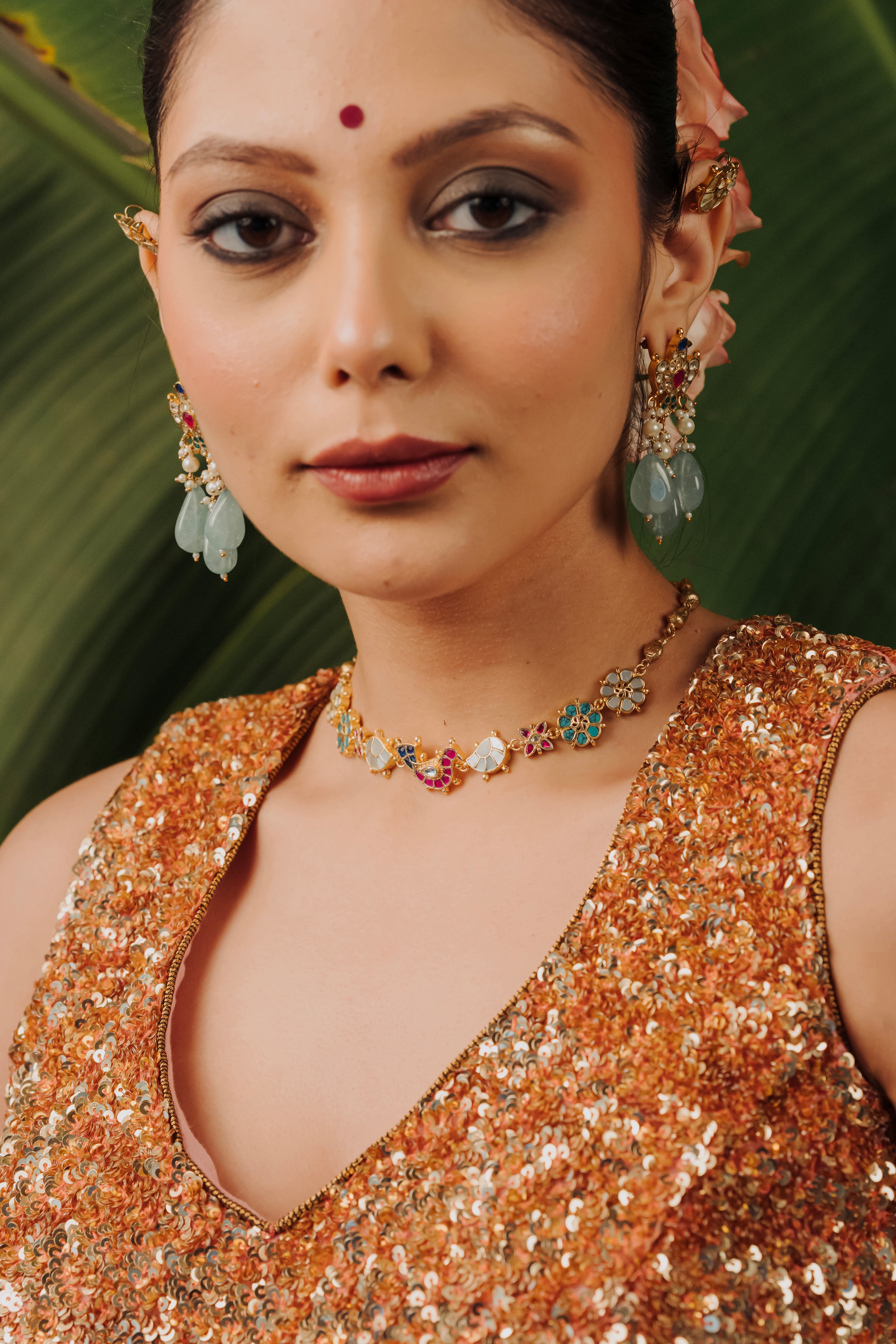 Woman wearing a handcrafted Phool Kundan choker necklace with matching earrings