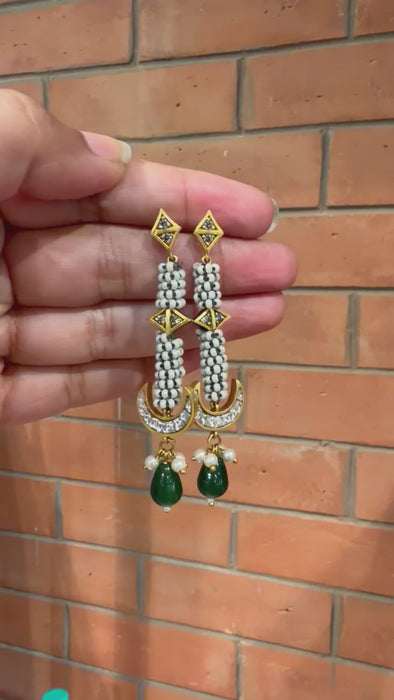 Handcrafted traditional Indian Moti Kundan statement earrings with pearl borders paired with white ethnic attire.
